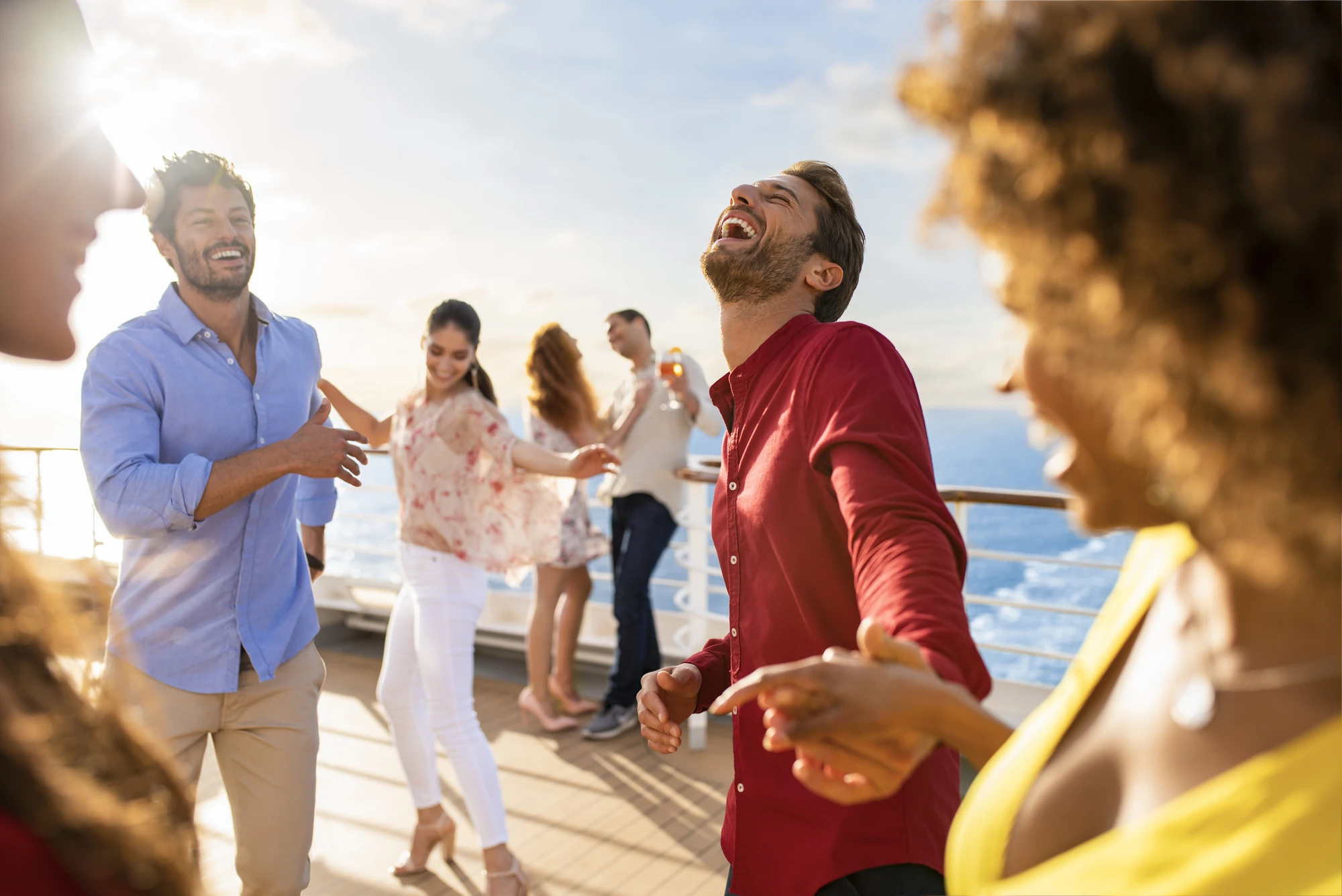 Freunde genießen eine fröhliche Zeit beim Tanzen auf dem Deck eines Kreuzfahrtschiffs.