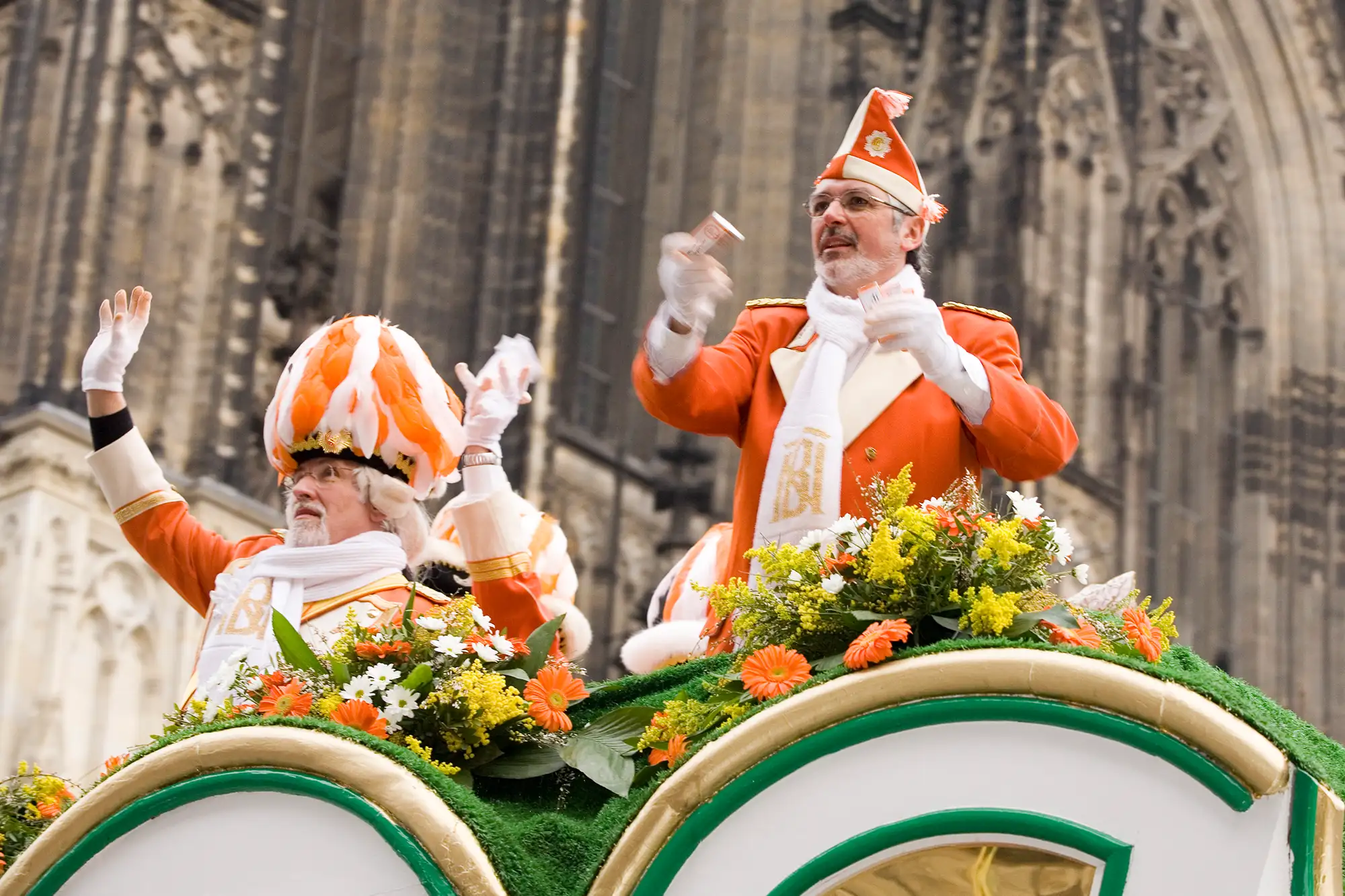 Karneval Köln - verkleidete Personen beim Karnevalsumzug auf einem Wagen vor dem Kölner Dom