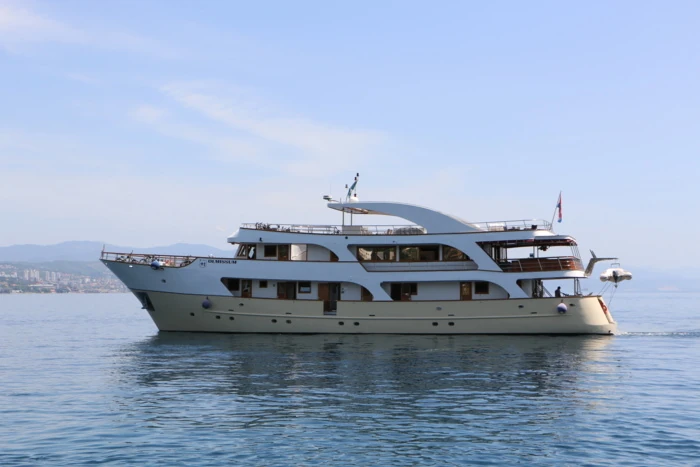 Eine elegante Yacht mit Blick auf die Berge im Hintergrund.