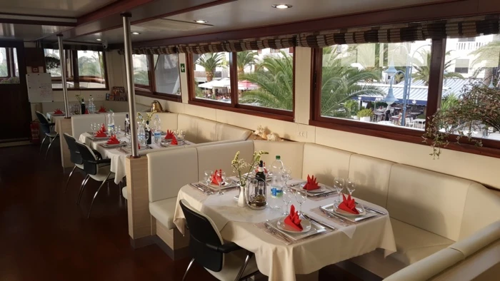 Gemütliches Ambiente eines Restaurants auf einem Boot mit großen Fenstern