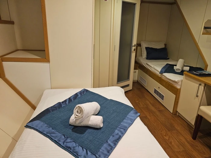 Gemütliches Schlafzimmer mit einem Bett, blauen Handtüchern und modernem Design.