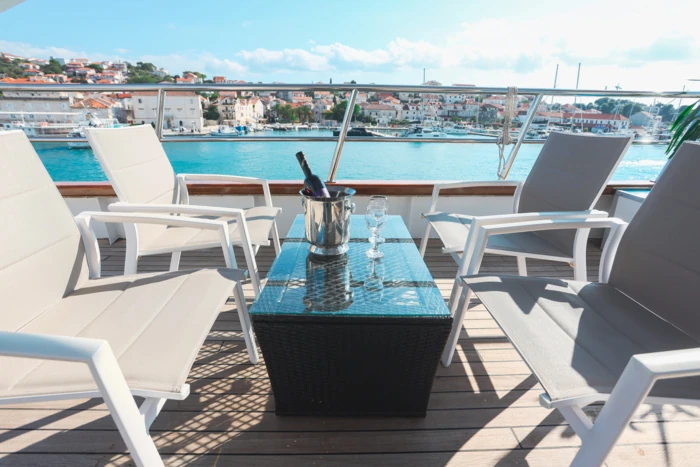 Yacht-Terrasse mit Schaumwein und Blick auf das Wasser.