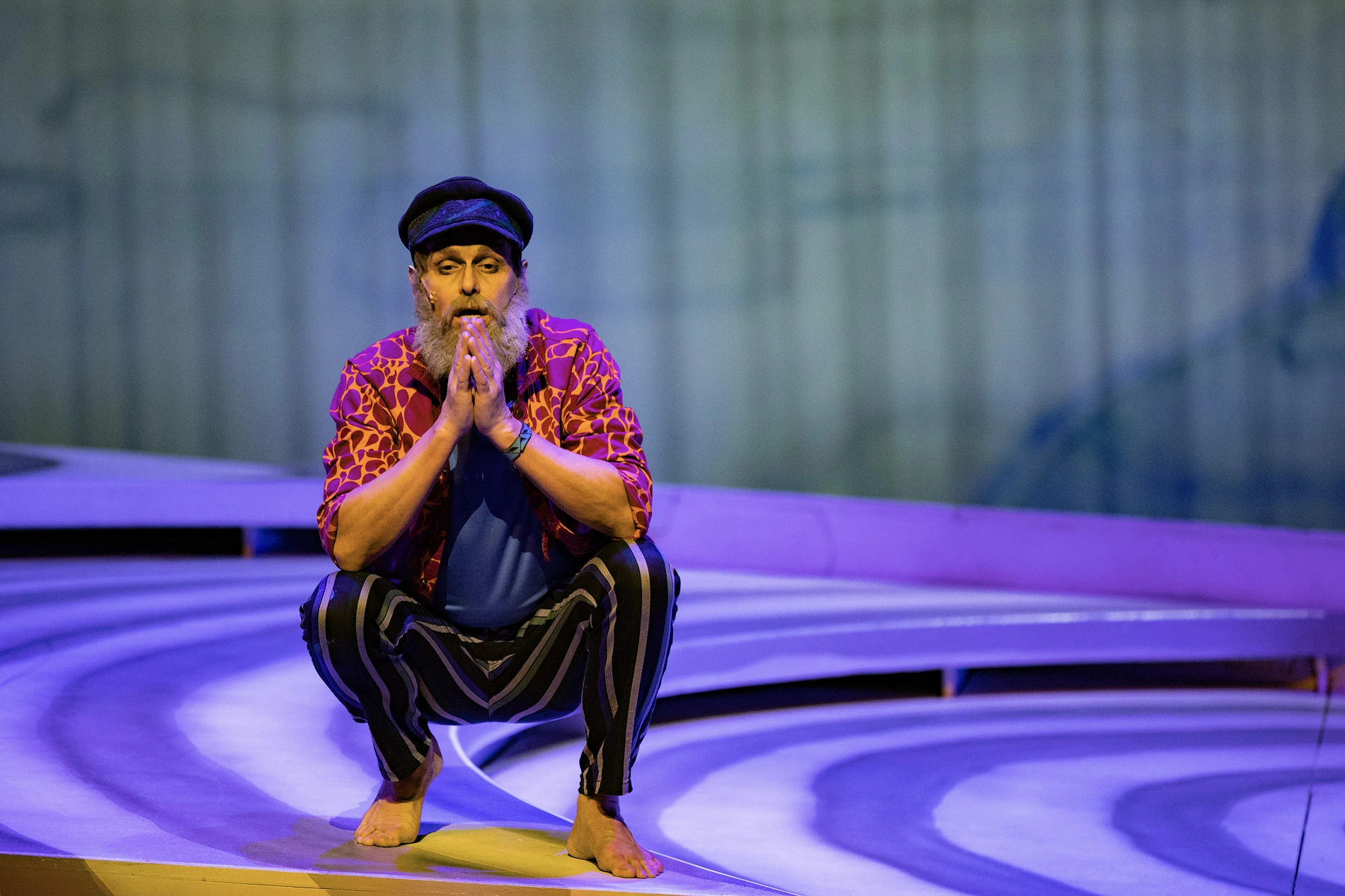 Ein Darsteller auf der Bühne in einer nachdenklichen Pose während einer Aufführung.