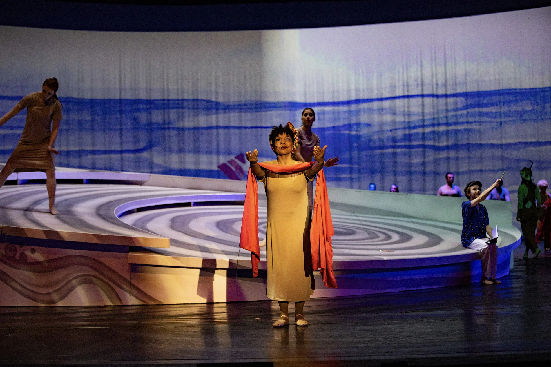 Blick auf die Theaterbühne mit Darstellern in verschiedenen Kostümen