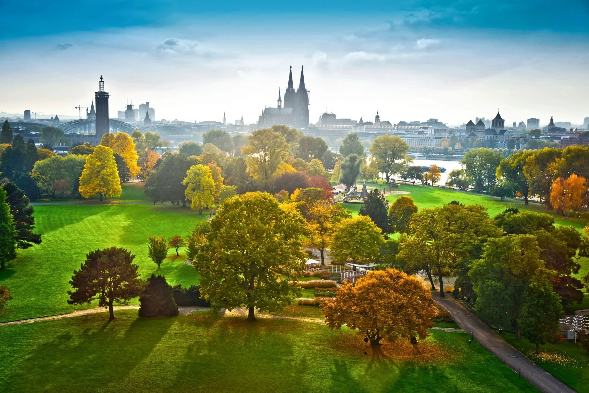 Ausblick auf den grünen Rheinpark in Köln im Herbst, Dom und Stadt im Hintergrund