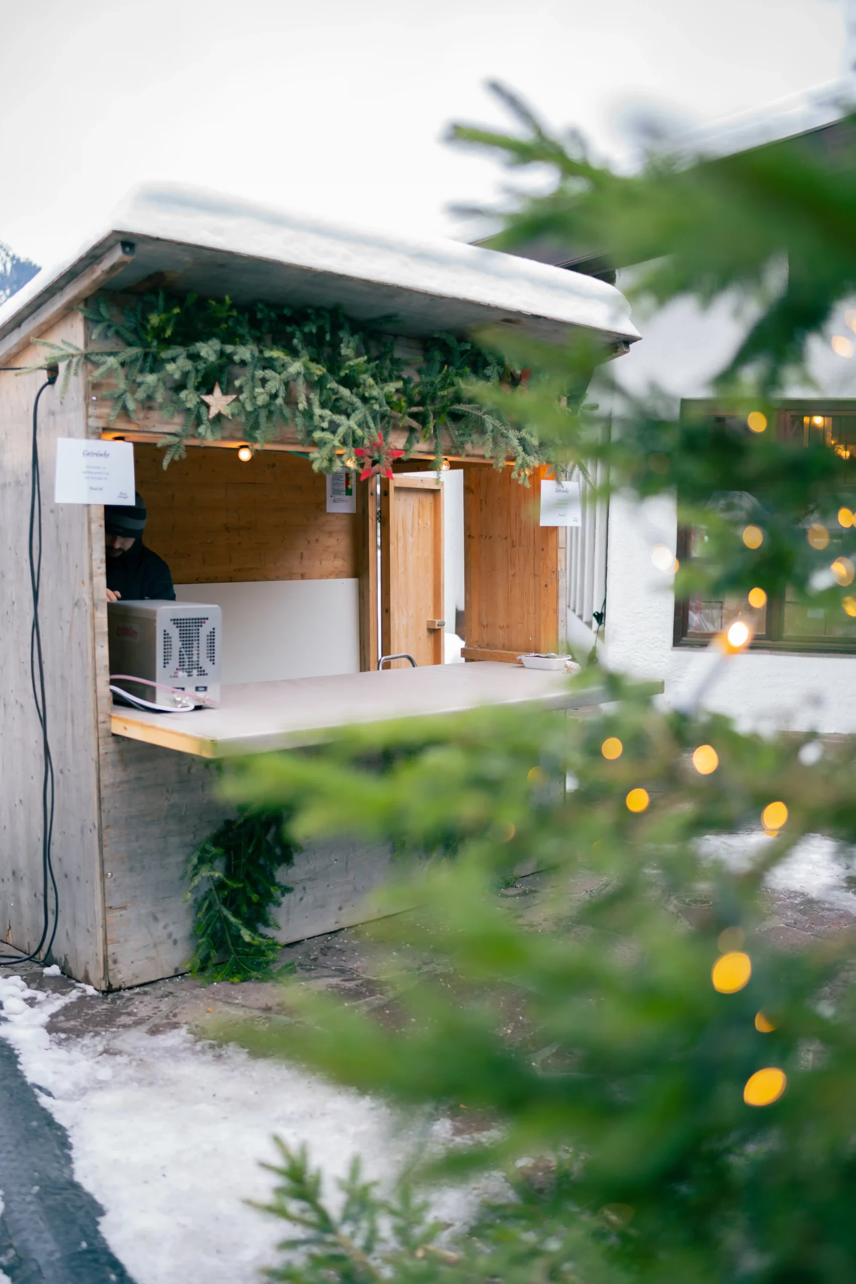 Glühweinstand am Bratwürste auf einem Grill beim Ammergauer Winterzauber.