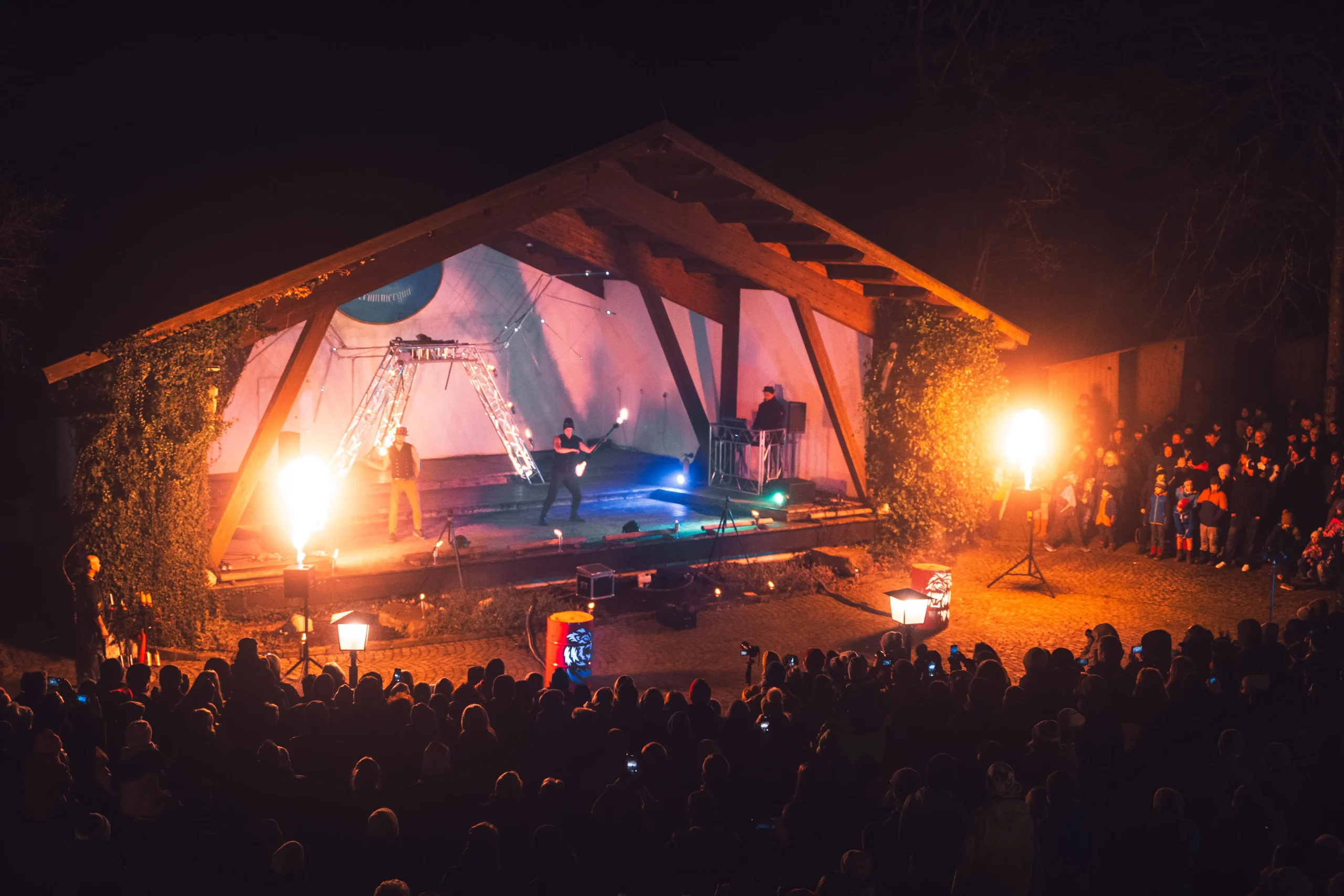 Konzert mit Pyrotechnik am Bratwürste auf einem Grill beim Ammergauer Winterzauber.
