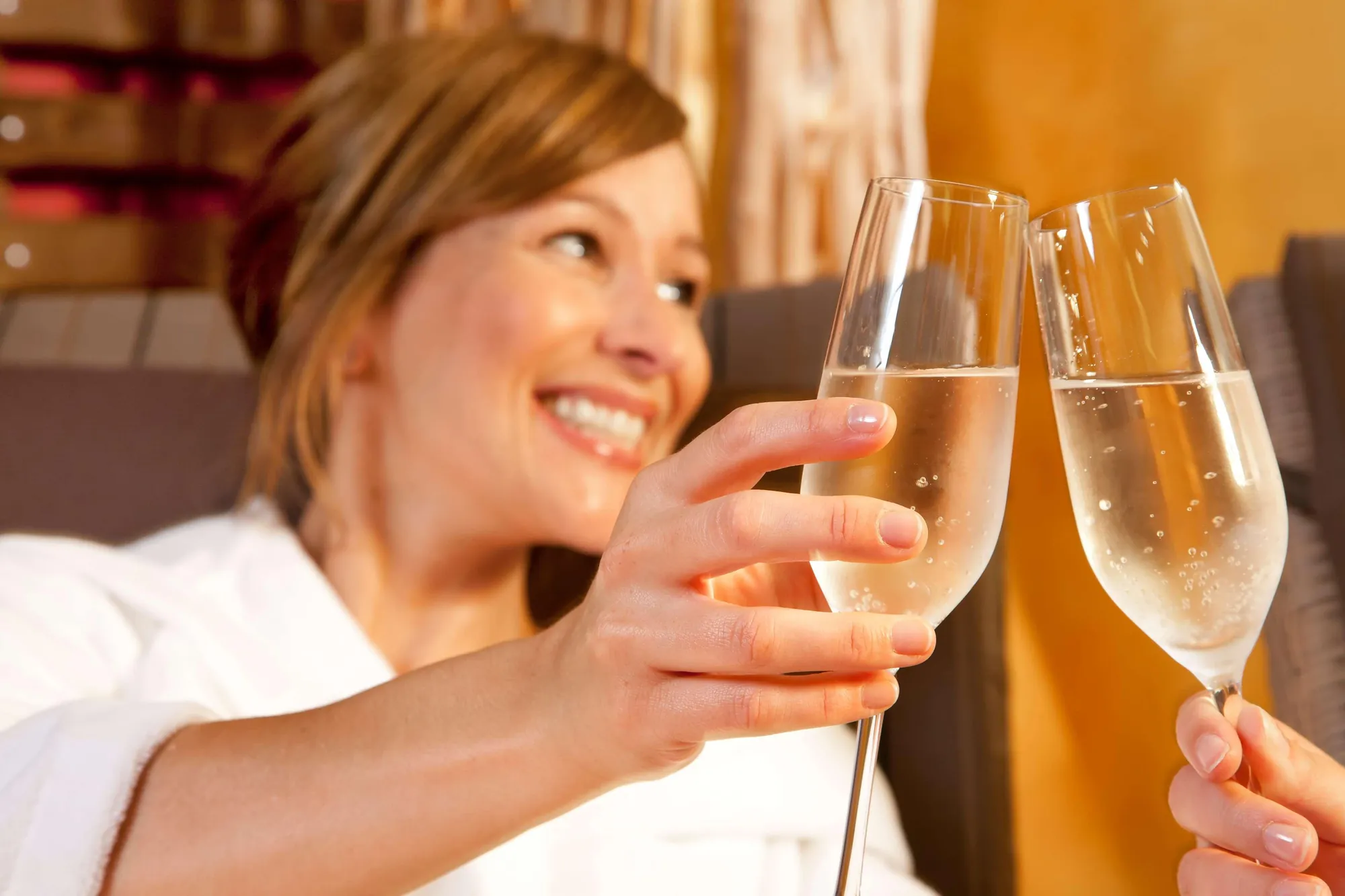 Anstoßen im Spa mit Sekt in entspannter Atmosphäre.