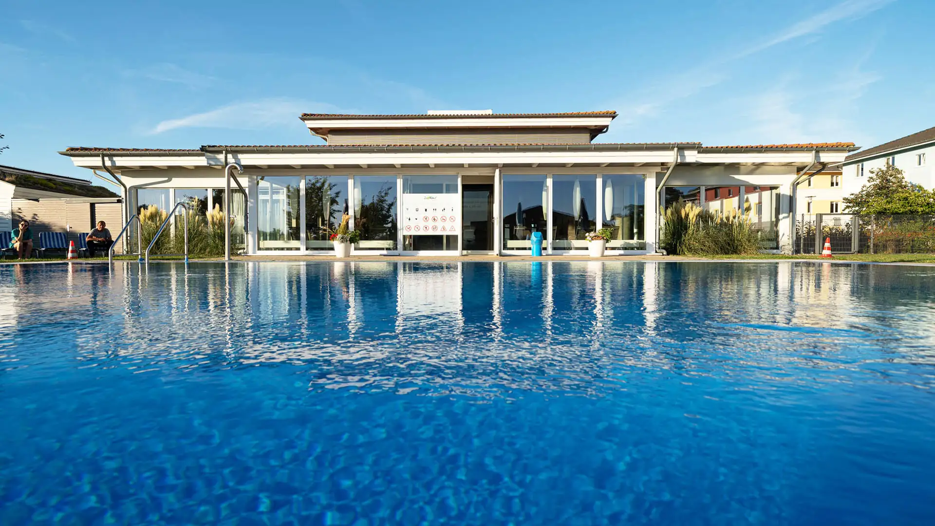 Sonniger Tag am Pool mit klarem Wasser und Pflanzen