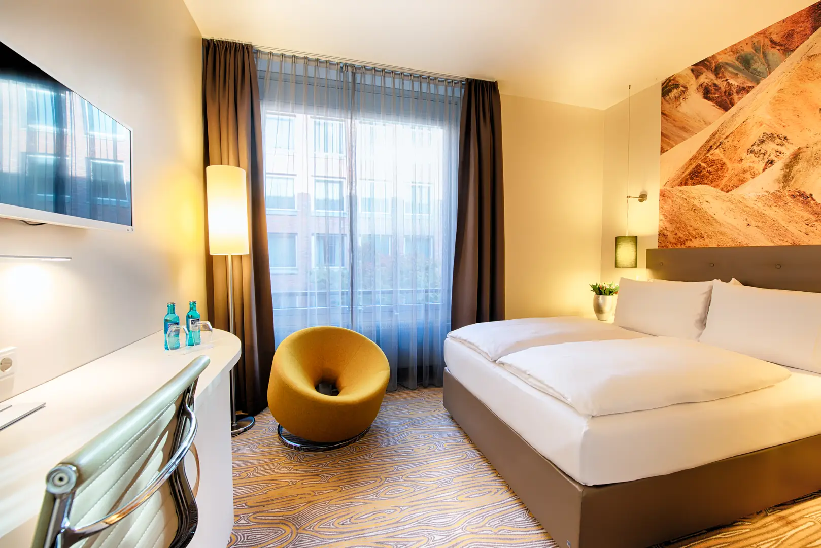 Achat Hotel Bremen City Business Gästezimmer mit Bett, Sessel und Fernseher