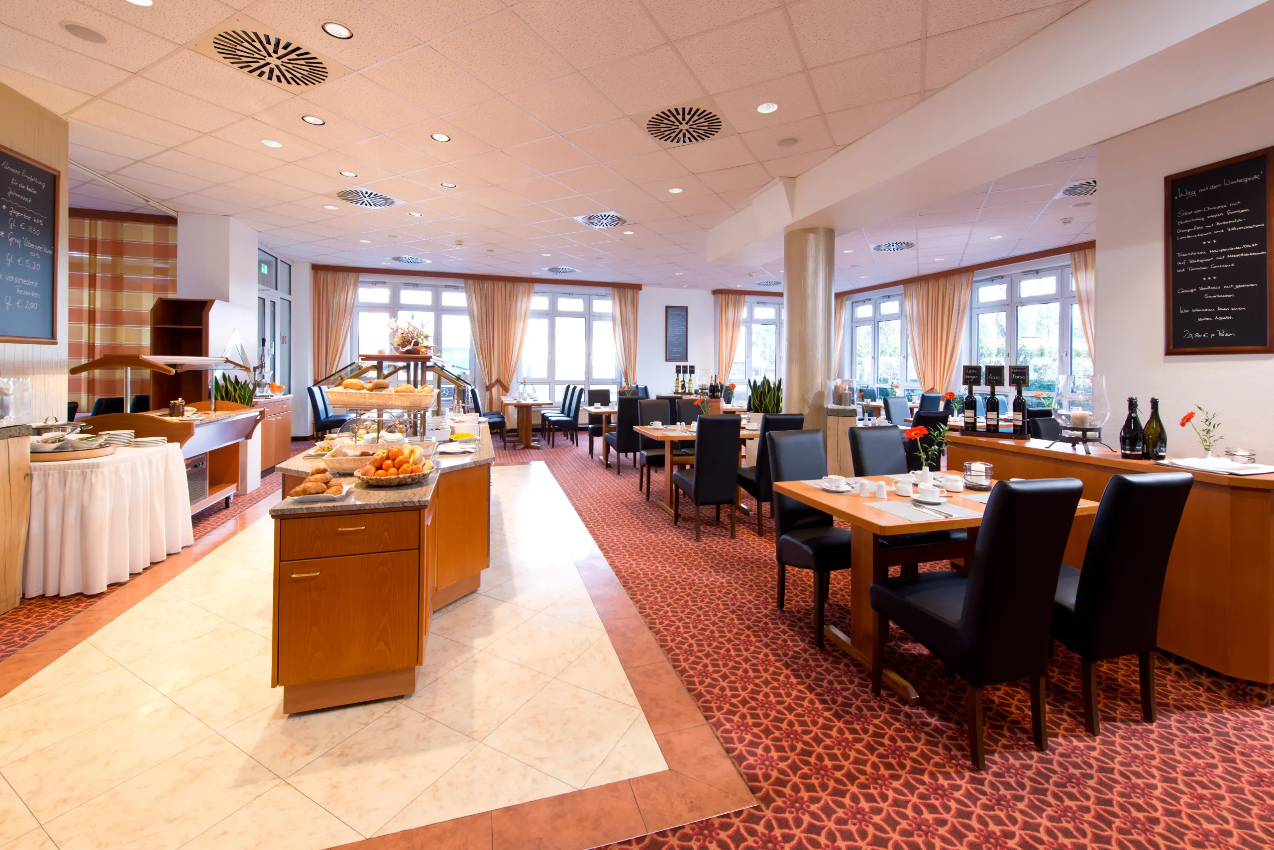 Helles Restaurant mit gedeckten Tischen, Buffetstationen und großen Fenstern mit Vorhängen im ACHAT Schwarzheide