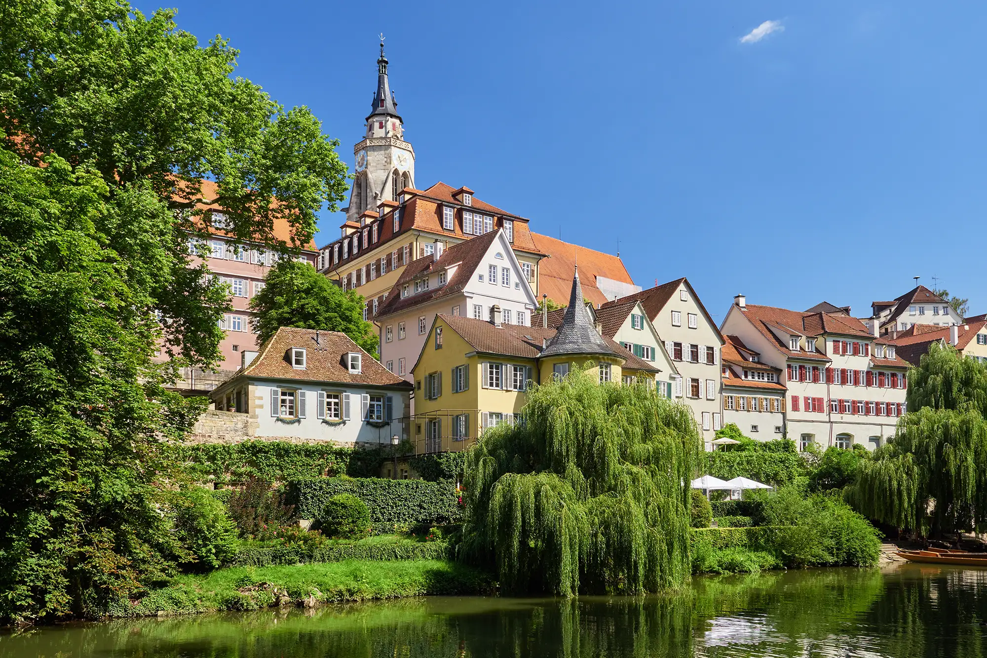 Schöne Ansichten vom Neckarufer aus auf die Altstadt und dem Turm der gotischen Stiftskirche St. Georg