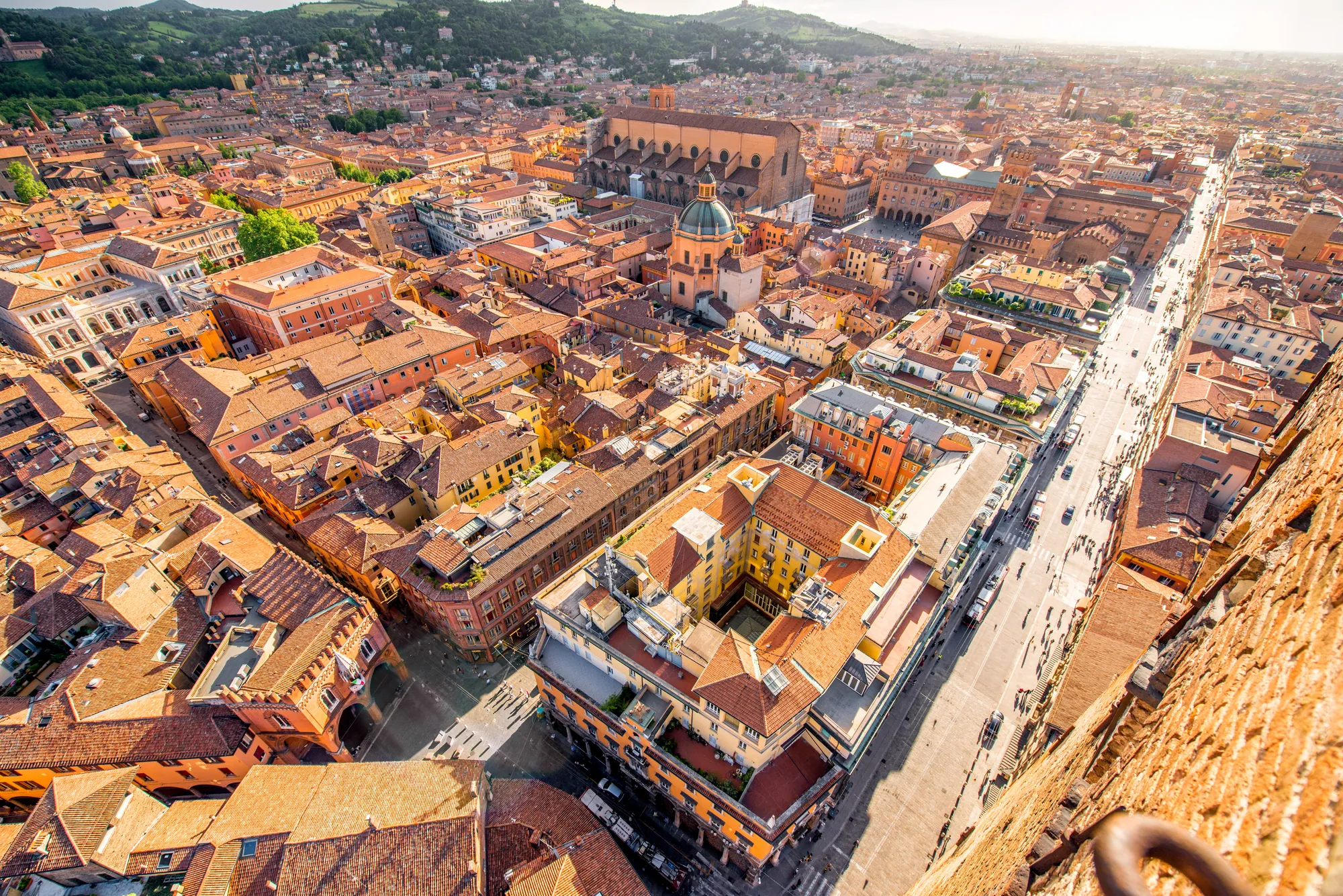 Vogelperspektive auf die beeindruckende historische Altstadt von Bologna. Die roten Ziegeldächer und mittelalterlichen Türme prägen das Stadtbild, während die engen Gassen und Plätze eine charmante, authentische Atmosphäre schaffen.