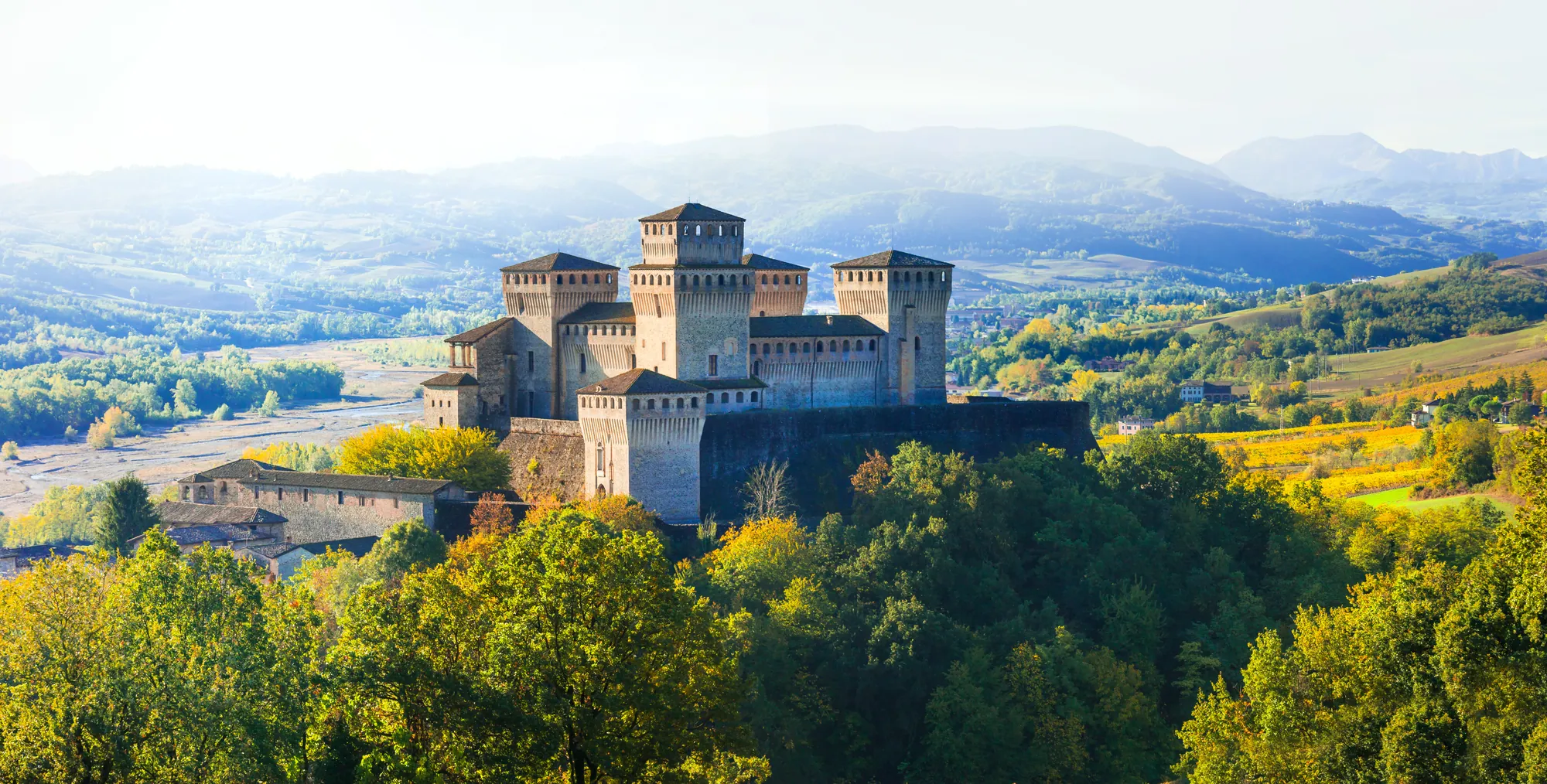Aussicht auf das majestätische Schloss Torrechiara, eingebettet in unberührte Natur in der Nähe von Parma. Umgeben von sanften Hügeln und üppigem Grün strahlt die historische Architektur des Schlosses eine zeitlose Eleganz aus und harmoniert perfekt mit der malerischen Landschaft.