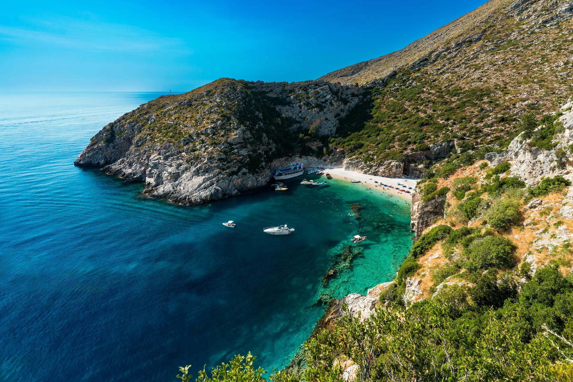 Albanien: Blick von oben auf die beeindruckende Grama-Bucht mit den vielfältigen Farben ihres Meeres