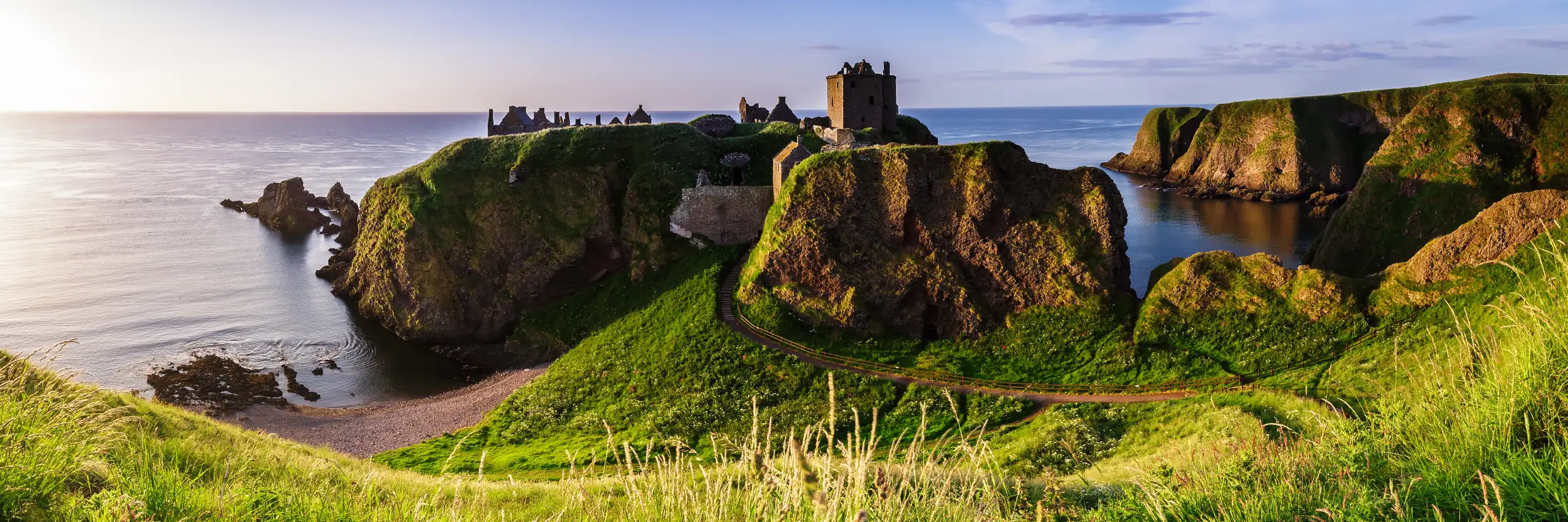 Panoramablick auf Dunnottar Castle bei Sonnenaufgang an der Ostküste Schottlands. Aberdeenshire.