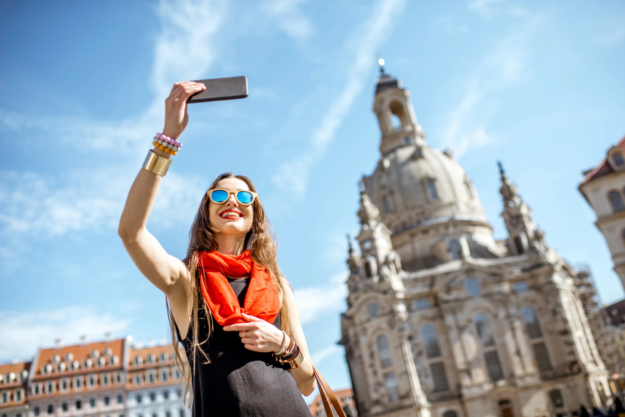 Frau in Dresden vor der Kirche macht selfie am helligem Tage