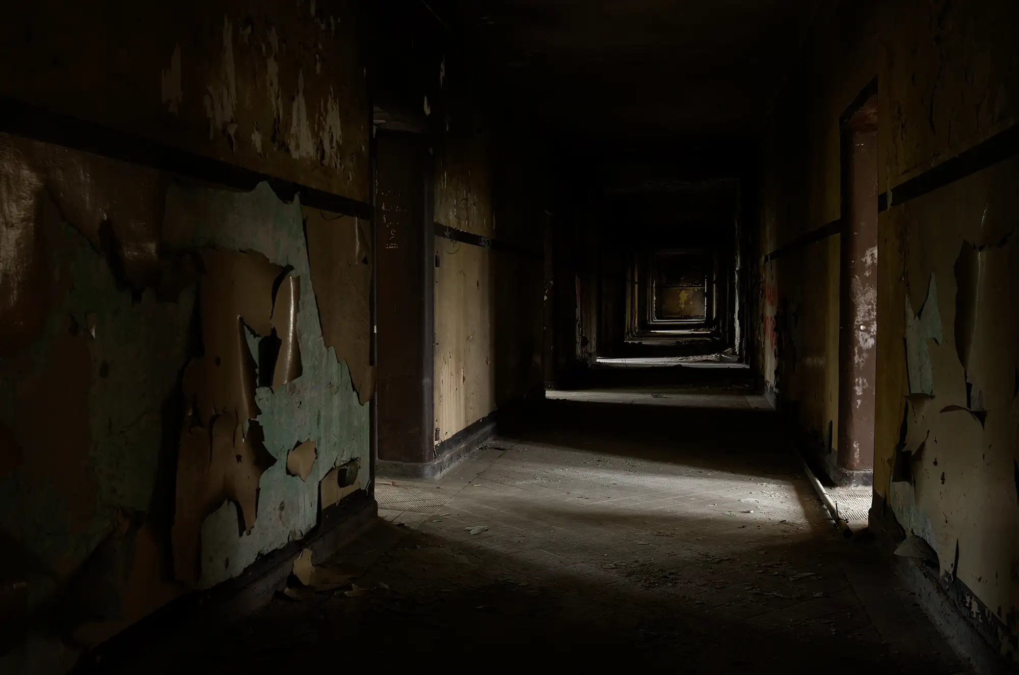 Gang in der Krampnitz Kaserne in Potsdam mit abgeblätterten Wänden mit Schatten und Licht durch Durchgänge