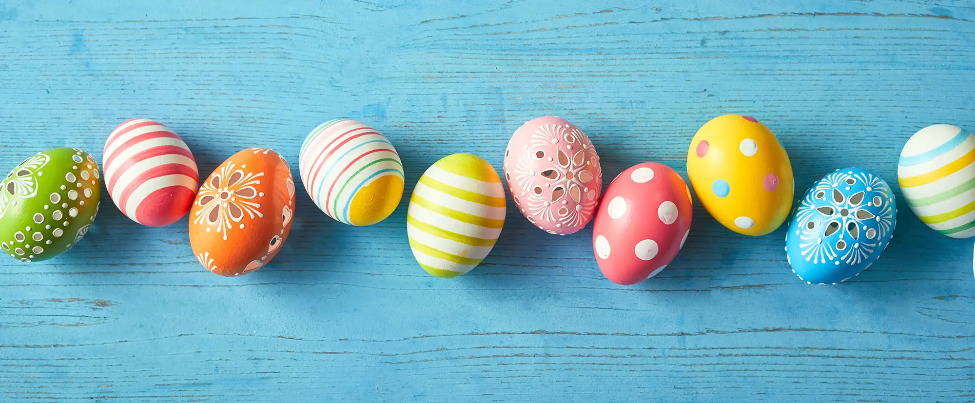 Ostereier Headerbild - Bunte Ostereier auf blauem Holz