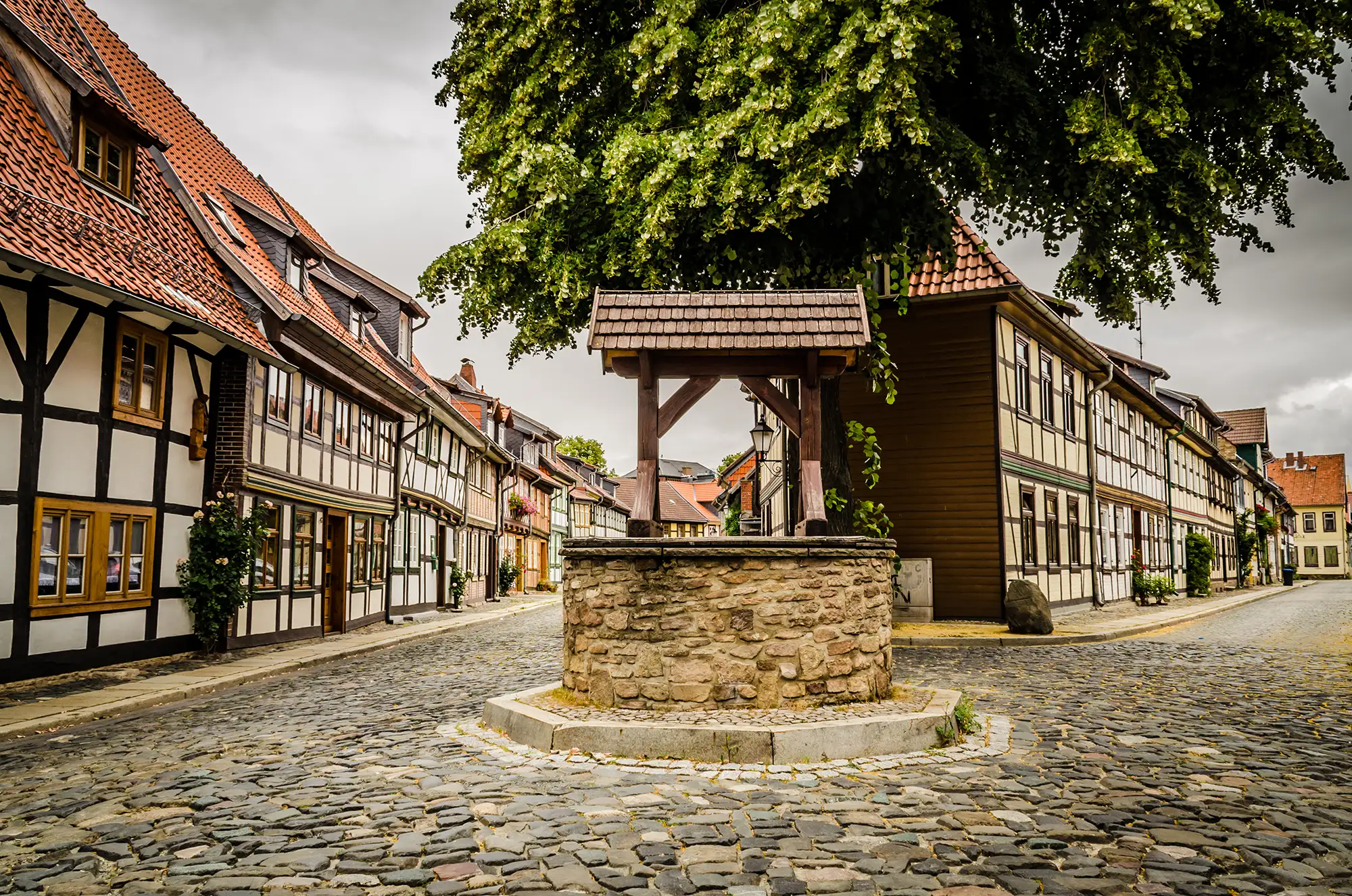 Brunnen in der Altstadt Wernigerode mit Fachwerkhäusern und Kopfsteinpflastern