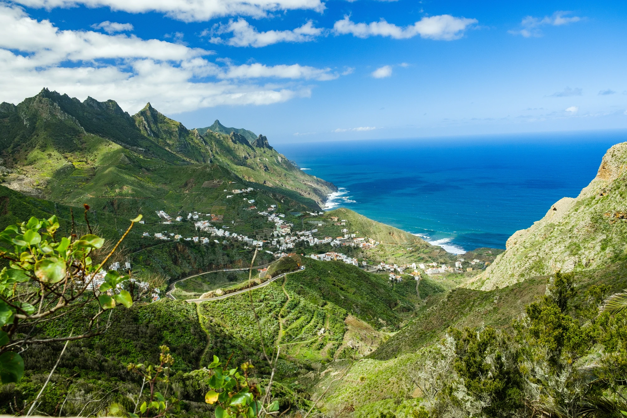 Felsformationen und Sandstrand an der Küste bei Sonnenaufgang mit ruhigem Meer und klarem Himmel. Teneriffa