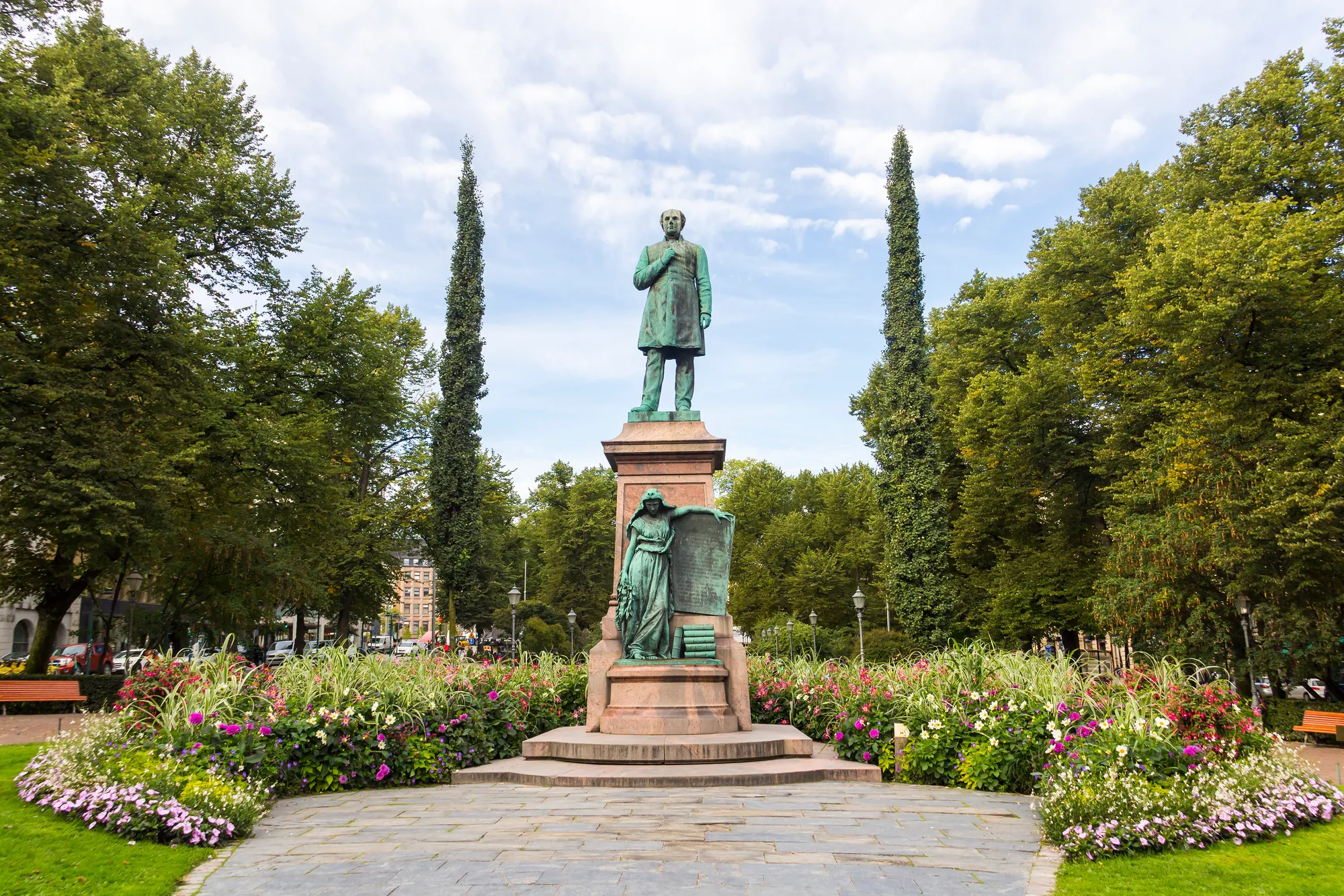 Esplanadi, ein Stadtpark mit der Statue von Runeberg, eingebettet in üppiges Grün und umgeben von blühenden Blumen, die eine einladende und ruhige Atmosphäre schaffen.