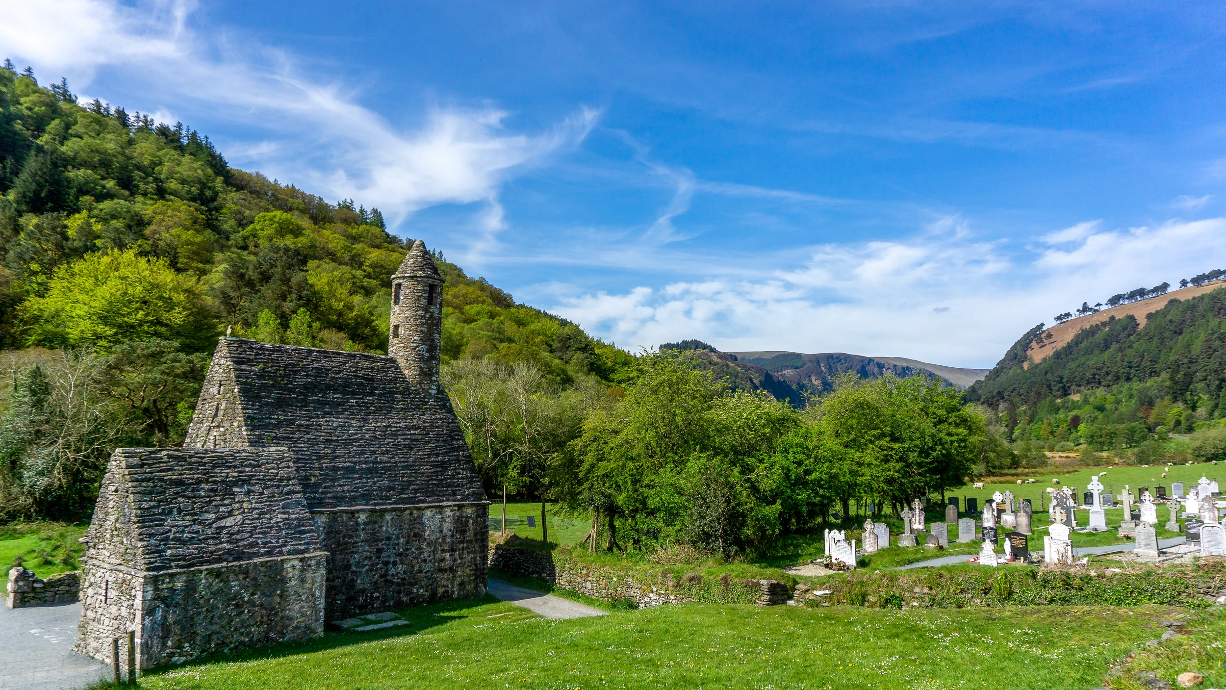 Historische Kapelle mit Steindach und Aussicht auf die Berge
