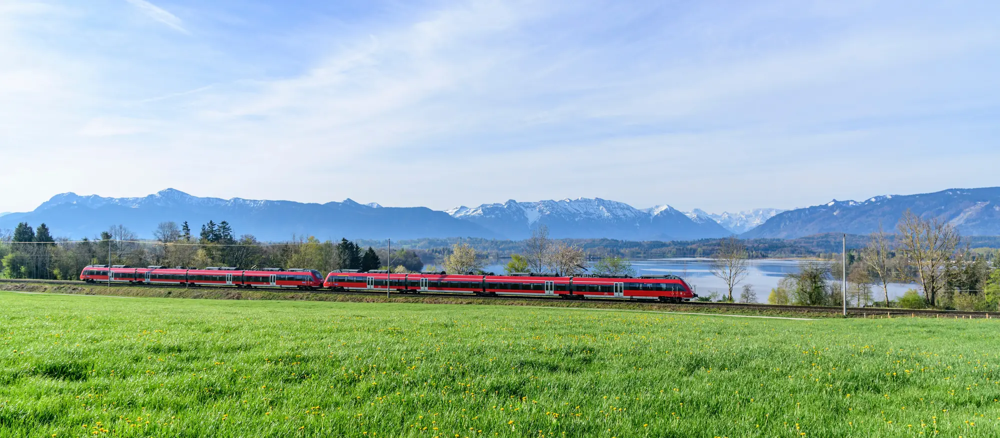 Regionalbahn passiert den Staffelsee nahe Murnau in Oberbayern, eine der schönsten Bahnstrecken Deutschlands.