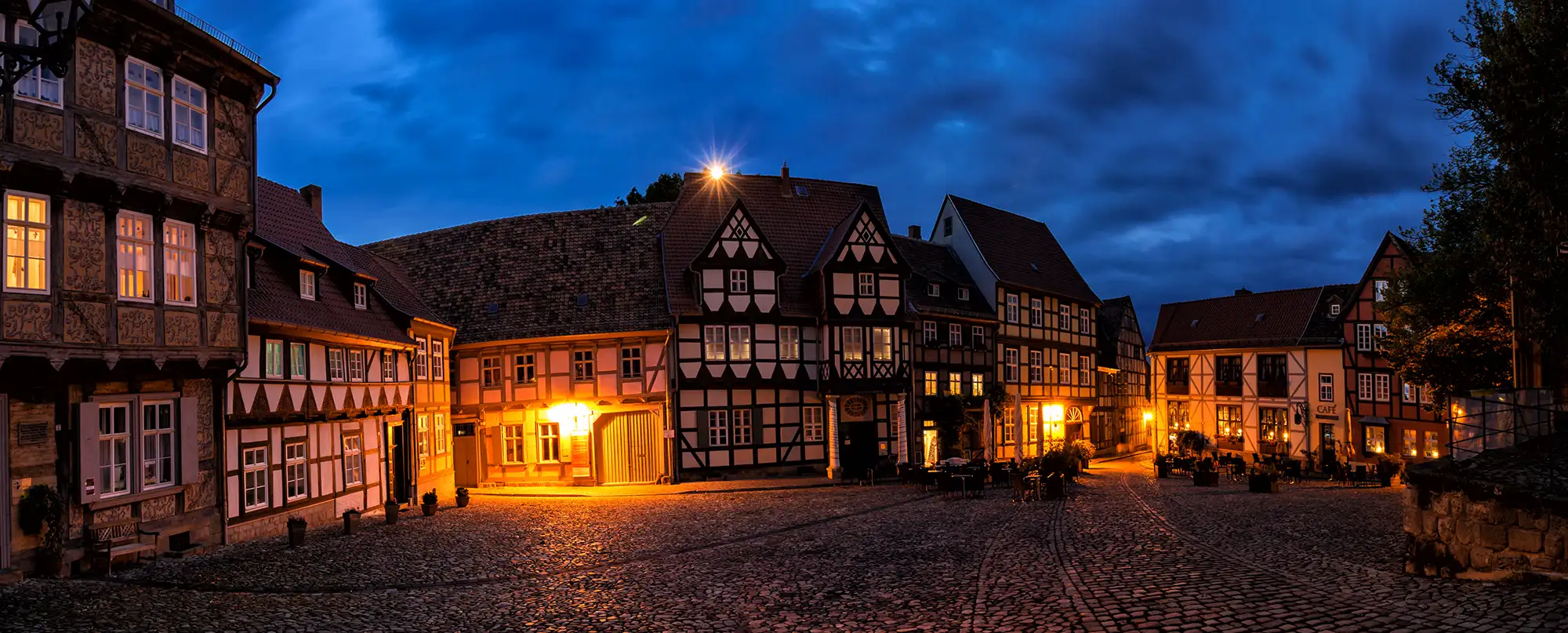 Panoramabild von Fachwerkhäusern in der beleuchteten Innenstadt von Quedlinburg bei Nacht