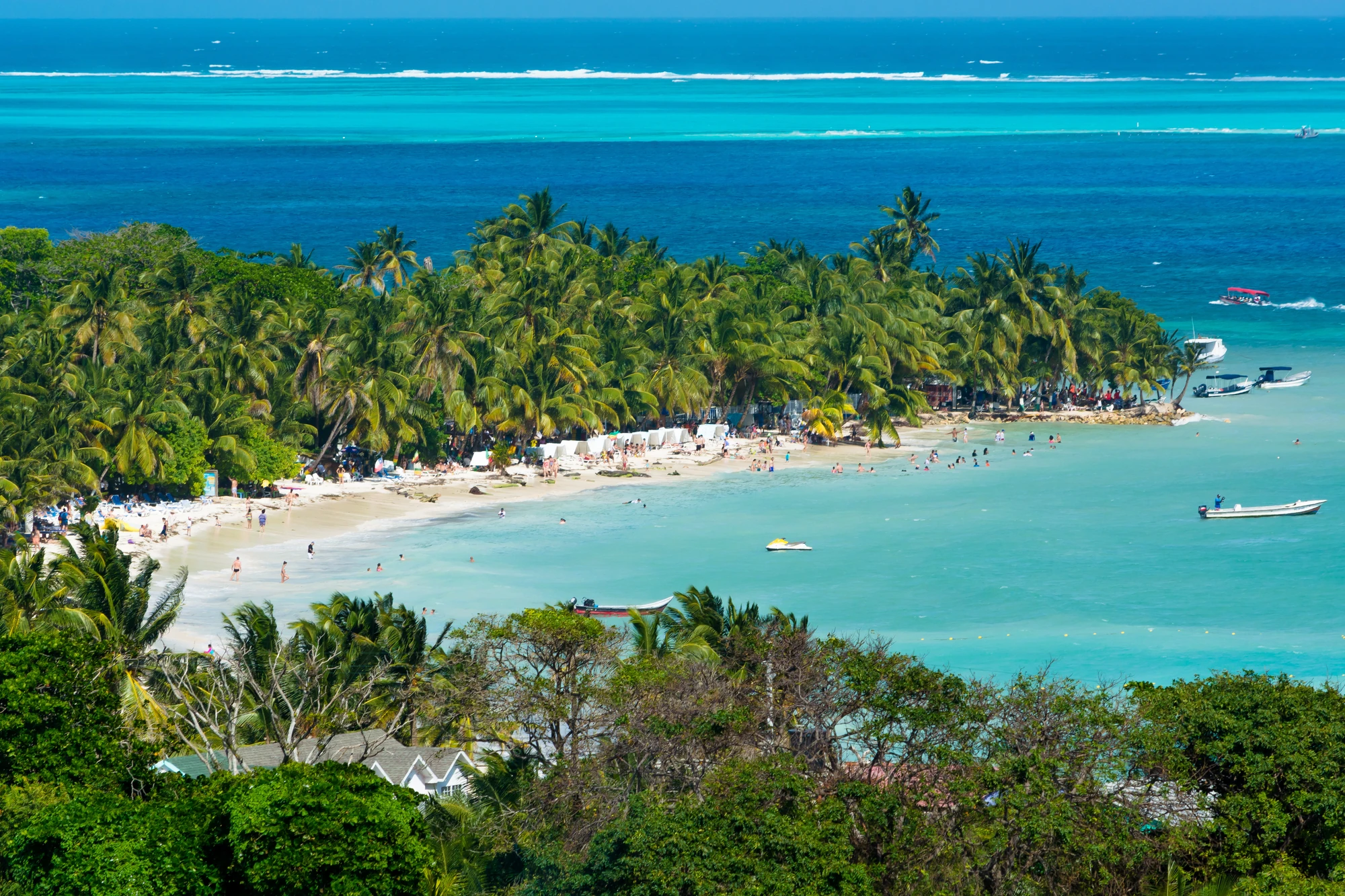 Tropische Insel mit üppiger Vegetation und Strandaktivitäten.