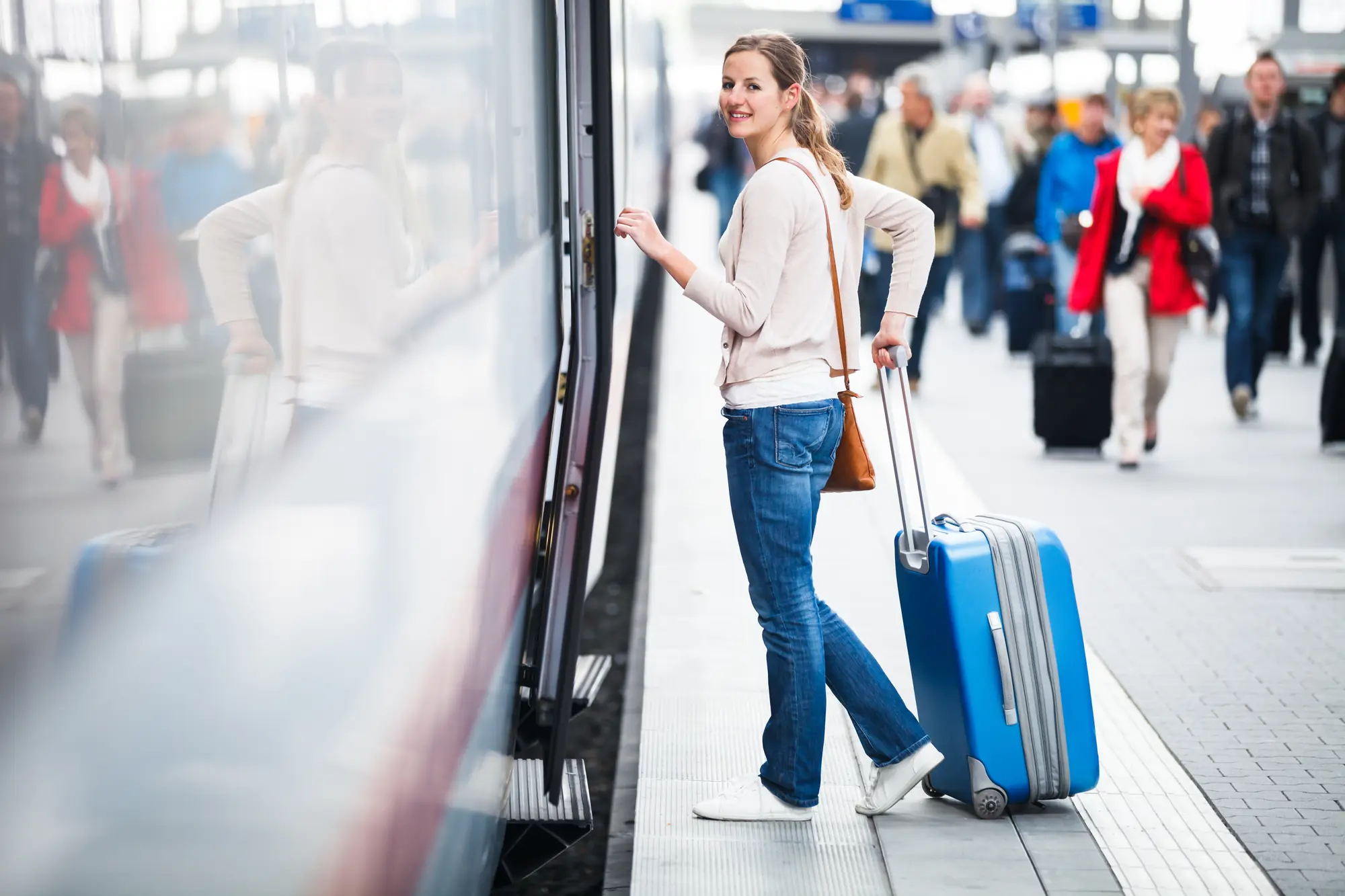 Junge Frau mit Koffer am Bahnsteig