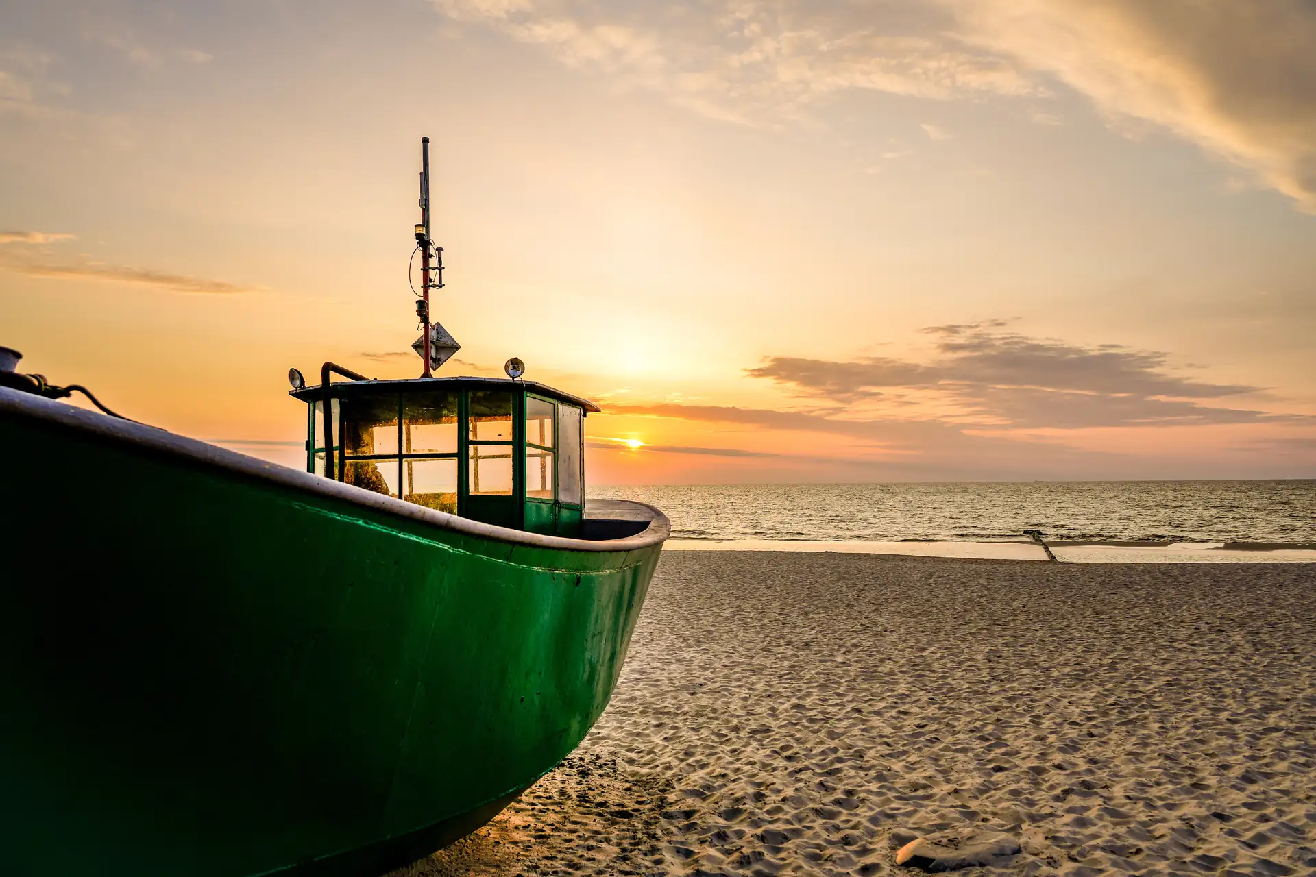 Fischerboot am Strand von Misdroy an der polnischen Ostseeküste bei untergehender Sonne