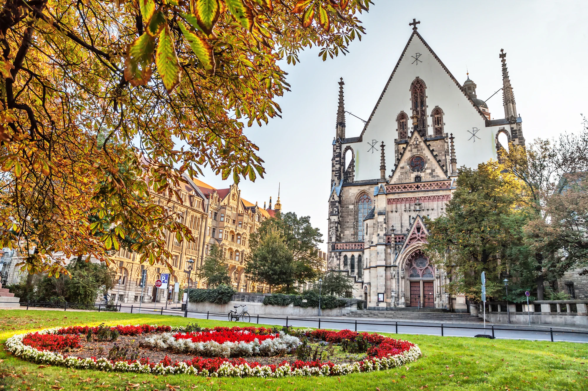 Leipzig - Historische Thomaskirche im Frühling, Blumen wachsen im Vorgarten