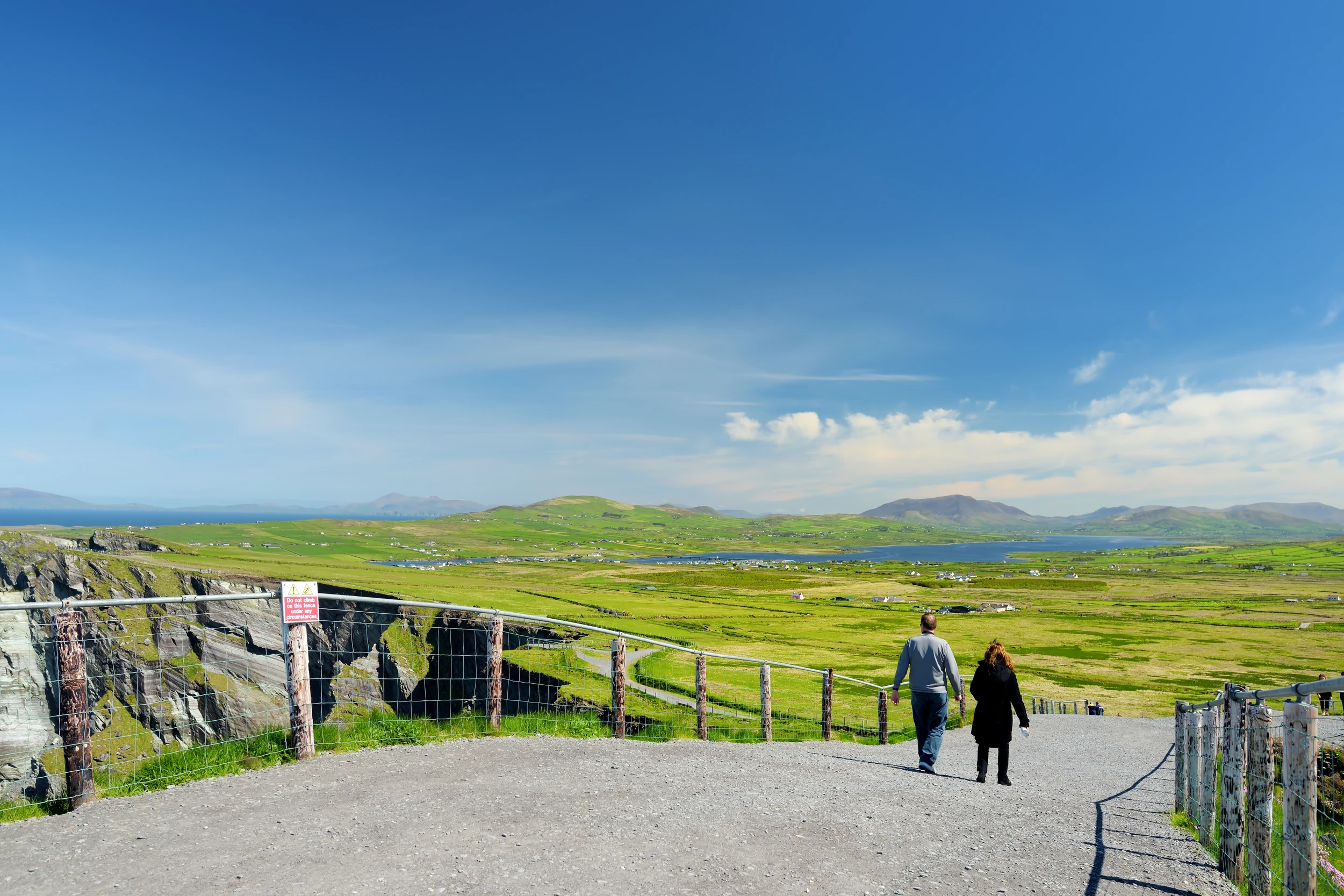 Panoramablick auf die irische Landschaft mit Wiesen und Bergen im Hintergrund.