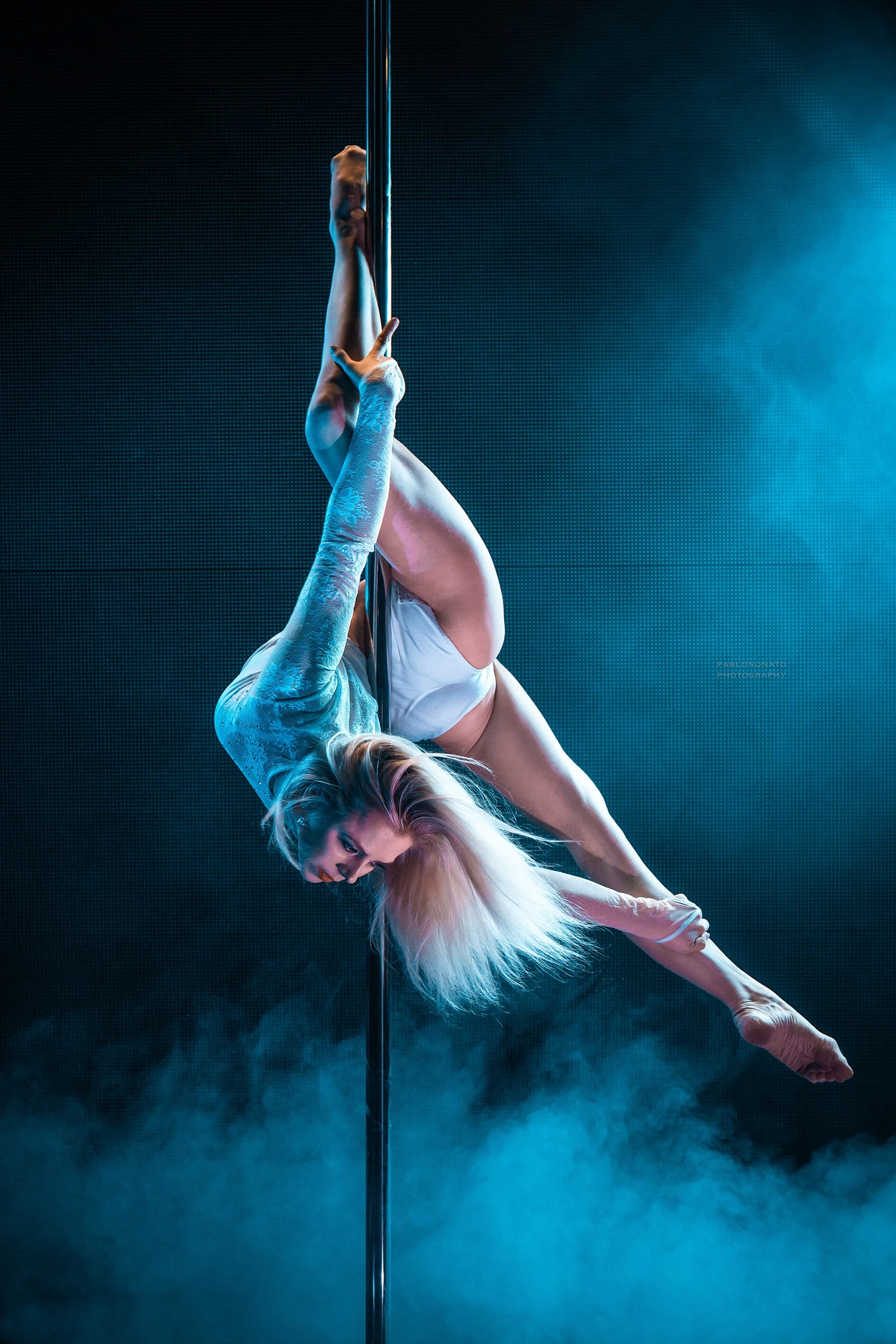 Anastasia Mazur - junge blonde Frau in einer eleganten Pose an einer Pole-Stange