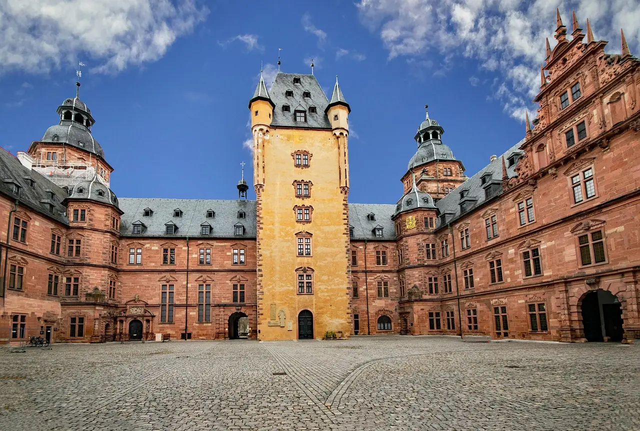 Historische Schlossarchitektur mit Türmen und roten Steinen.