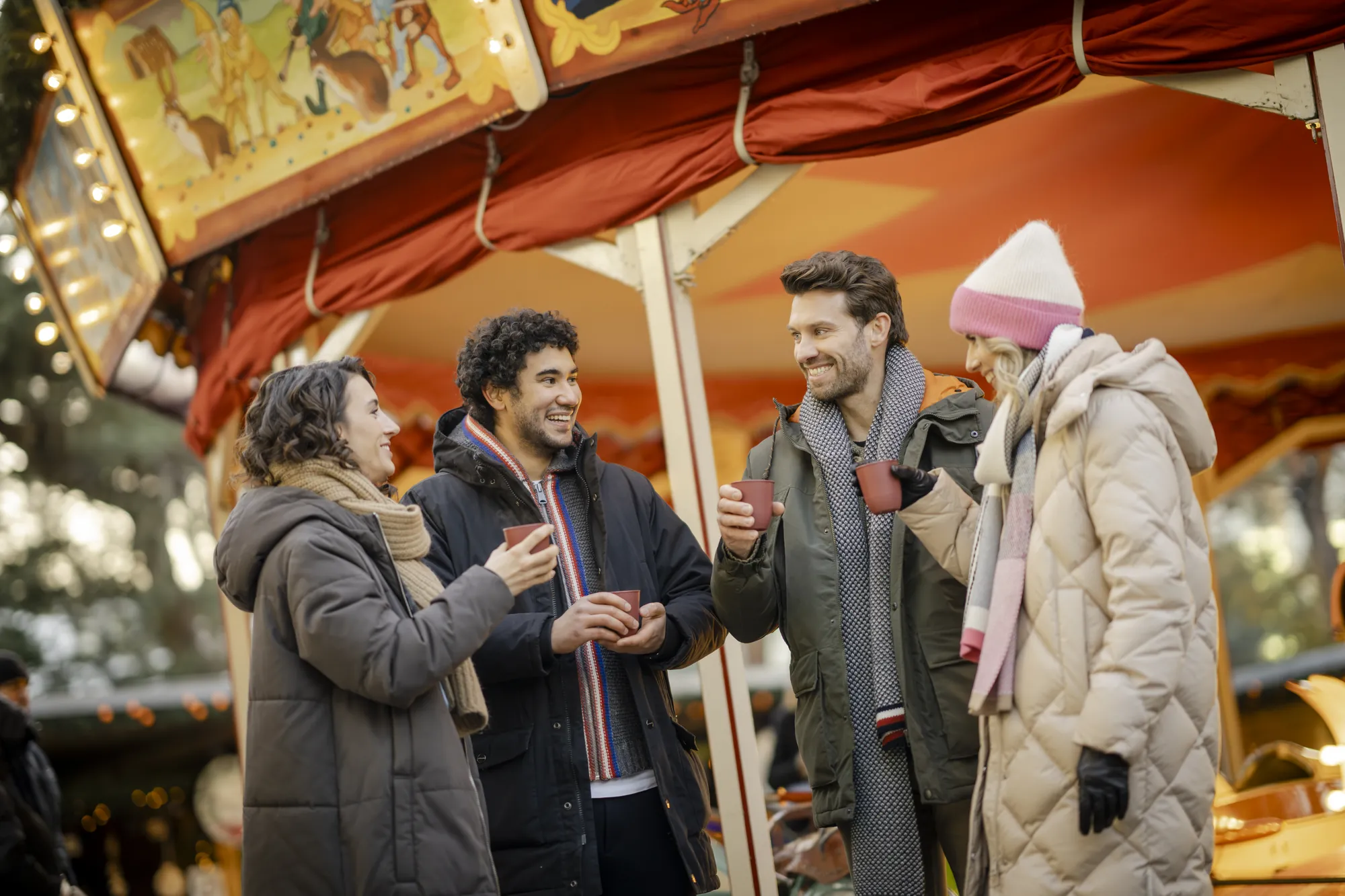 Autostadt Wolfsburg - Freunde oder Kolleg*innen mit einem Getränk unterhalten sich vor einem Karussel