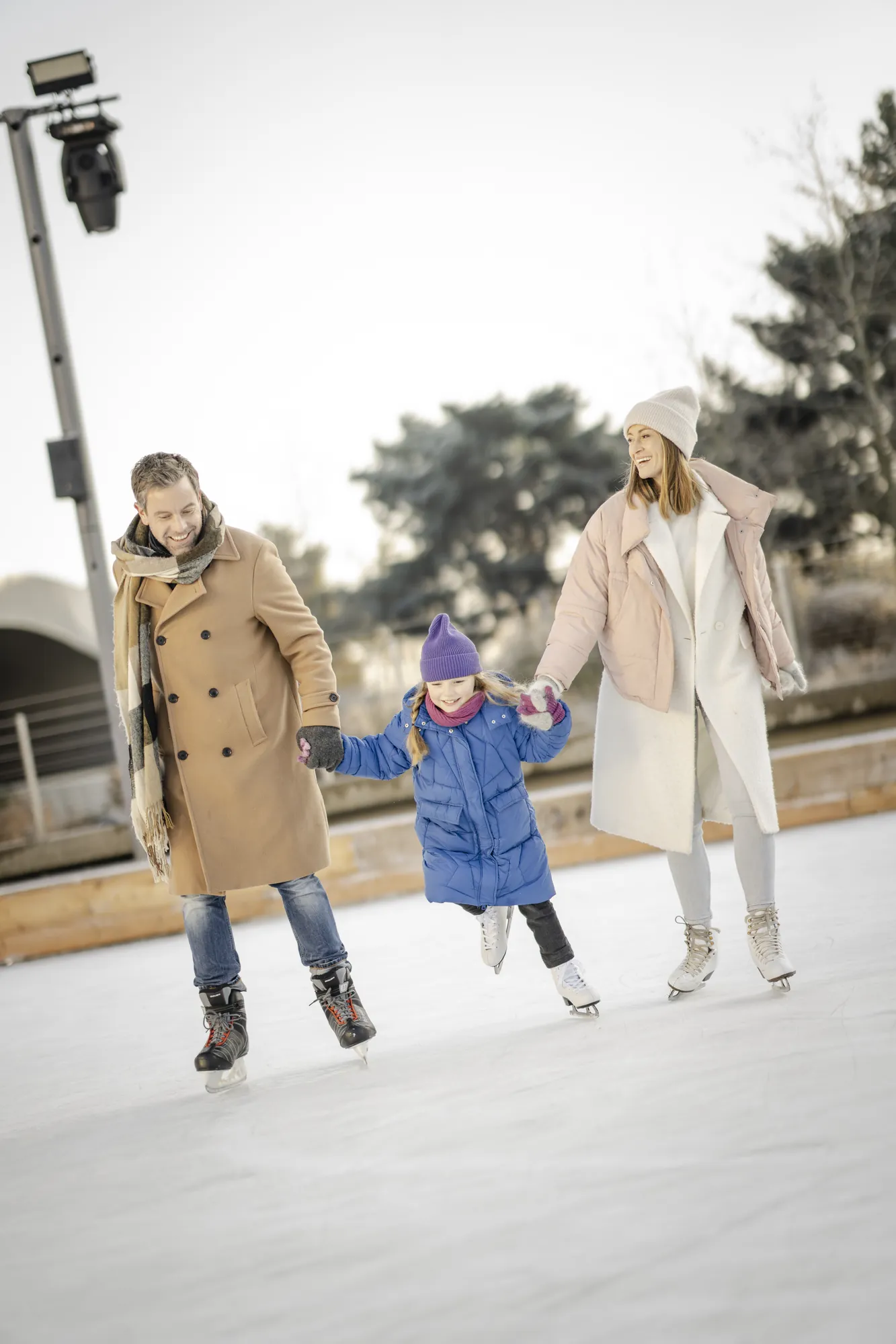 Autostadt Wolfsburg - Eltern und Tochter auf der Eisbahn halten Händchen
