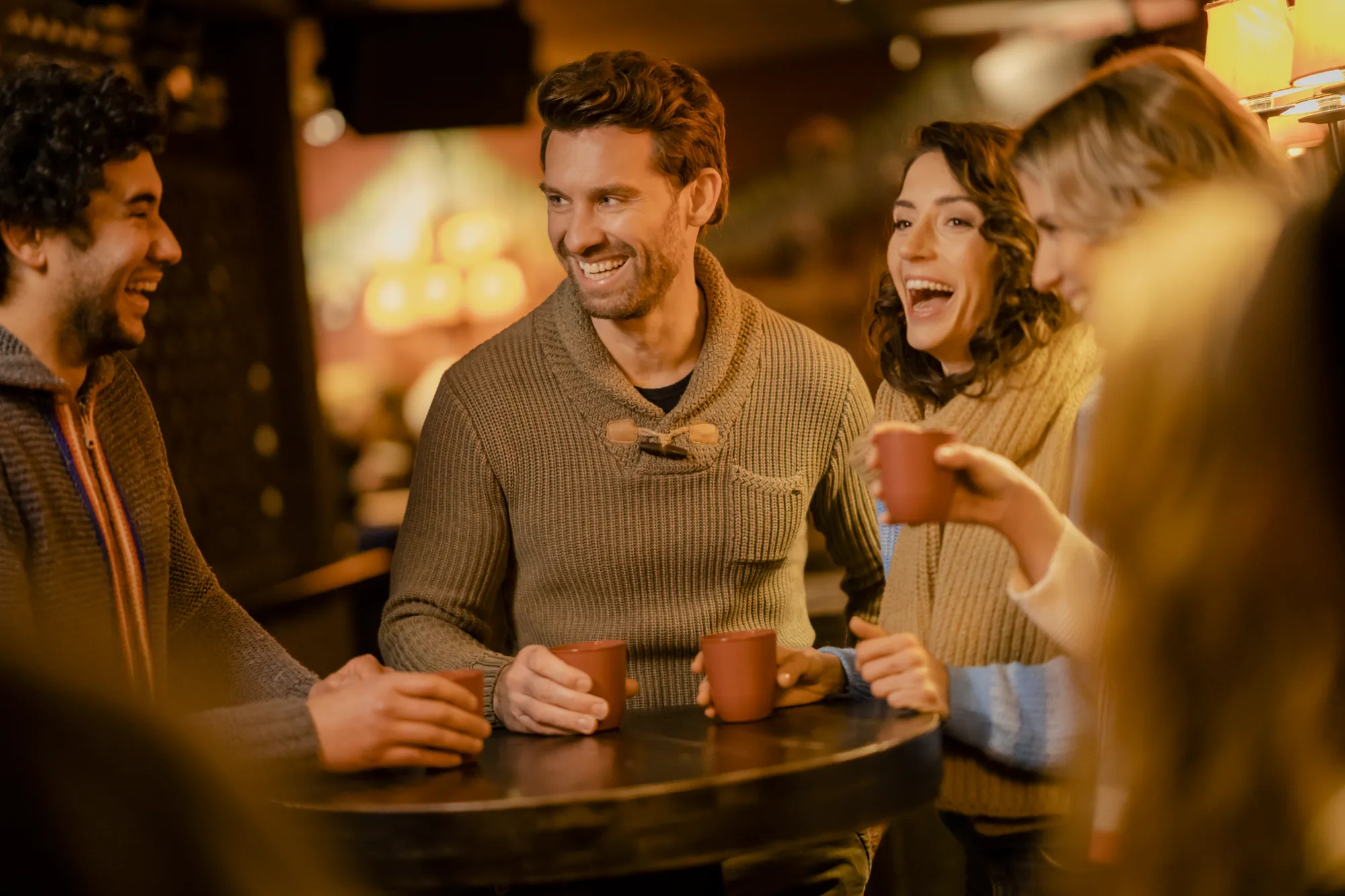 Autostadt Wolfsburg - Freunde oder Kolleg*innen sitzen Drinnen gemütlich am Tisch und unterhalten sich