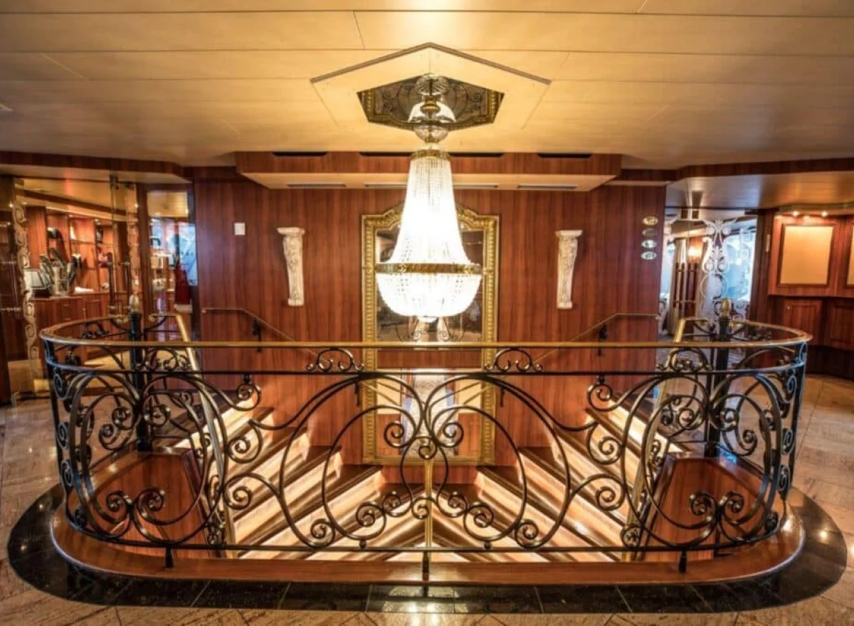 Luxuriöse Lobby auf einem Kreuzfahrtschiff mit eleganten Designelementen und Beleuchtung.