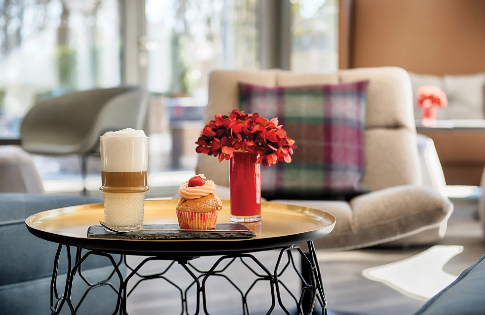 Eine gemütliche Café-Ecke mit einer Tasse Kaffee und einem bunten Cupcake.