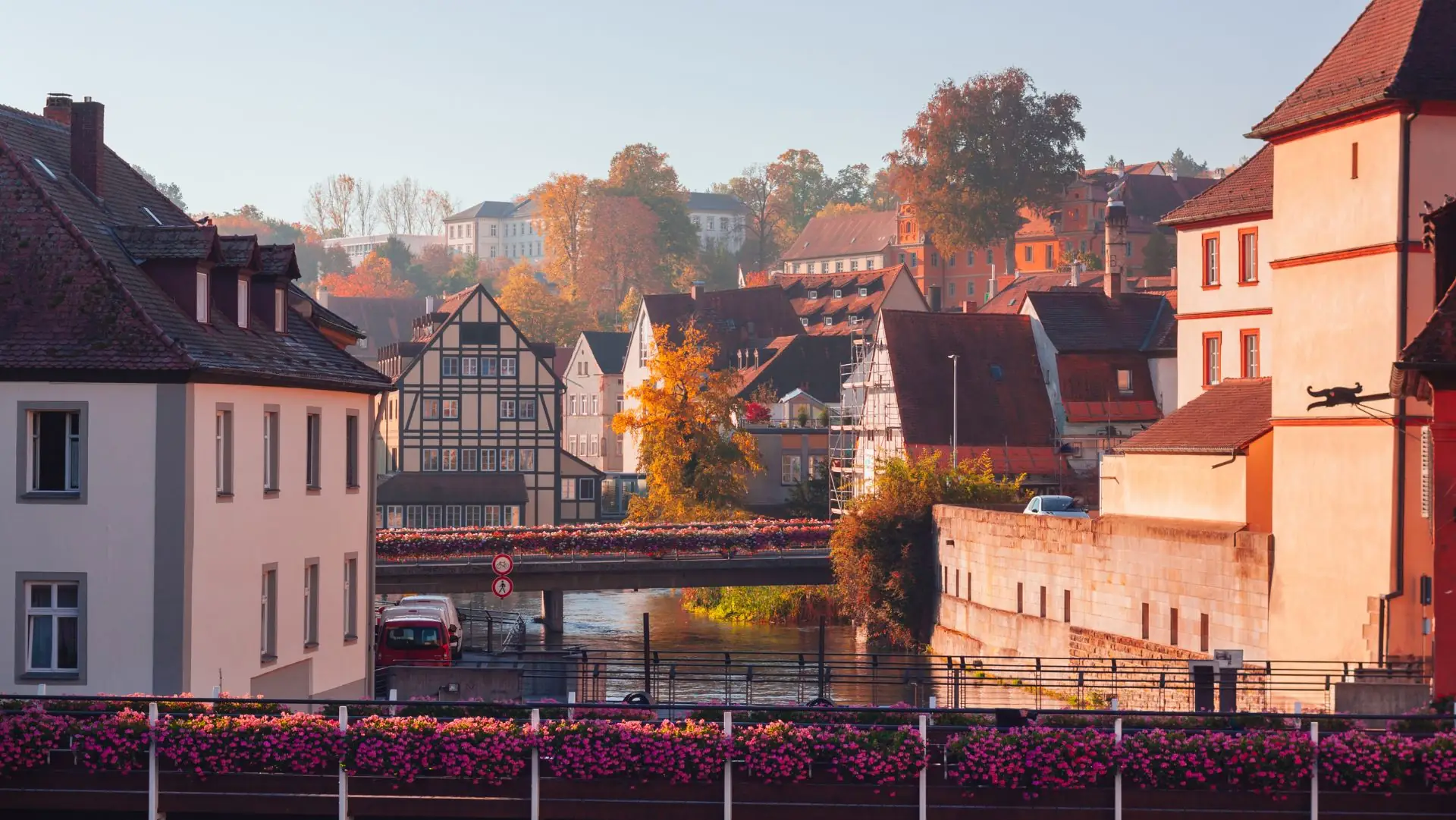 Blick auf die historische Altstadt von Bamberg mit Fachwerkhäusern und herbstlich gefärbten Bäumen am Flussufer