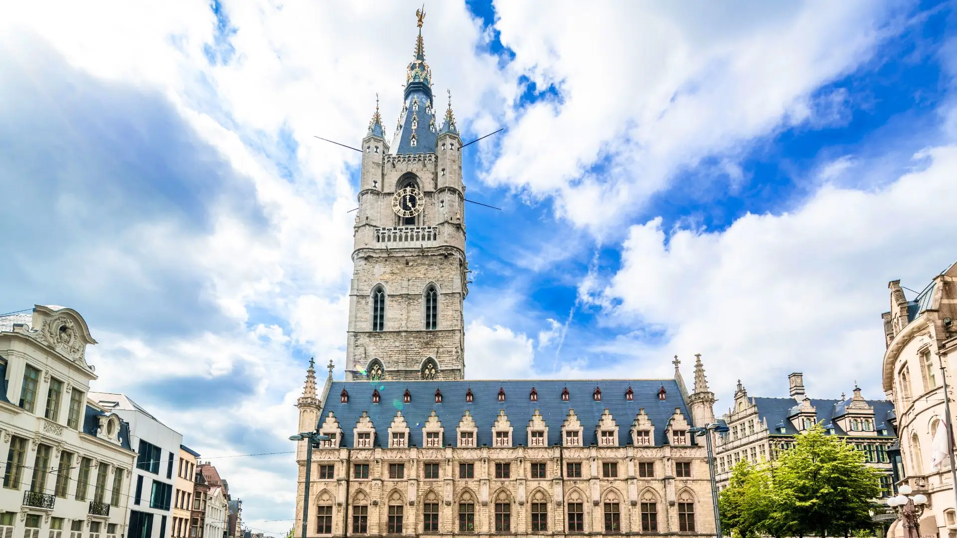 Historisches Gebäude in Gent mit dem Gotthardturm im Hintergrund