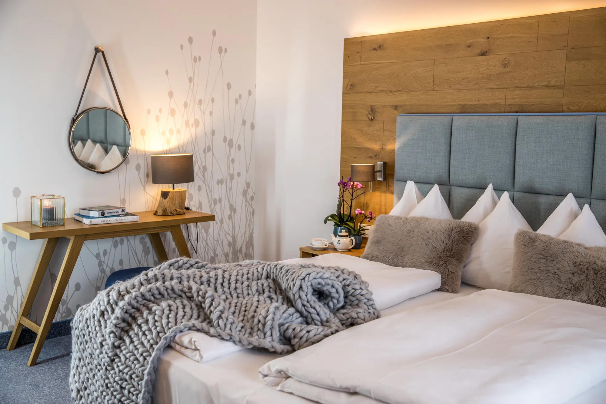 Sonnendurchflutetes Hotelzimmer mit Schreibtisch und Bett