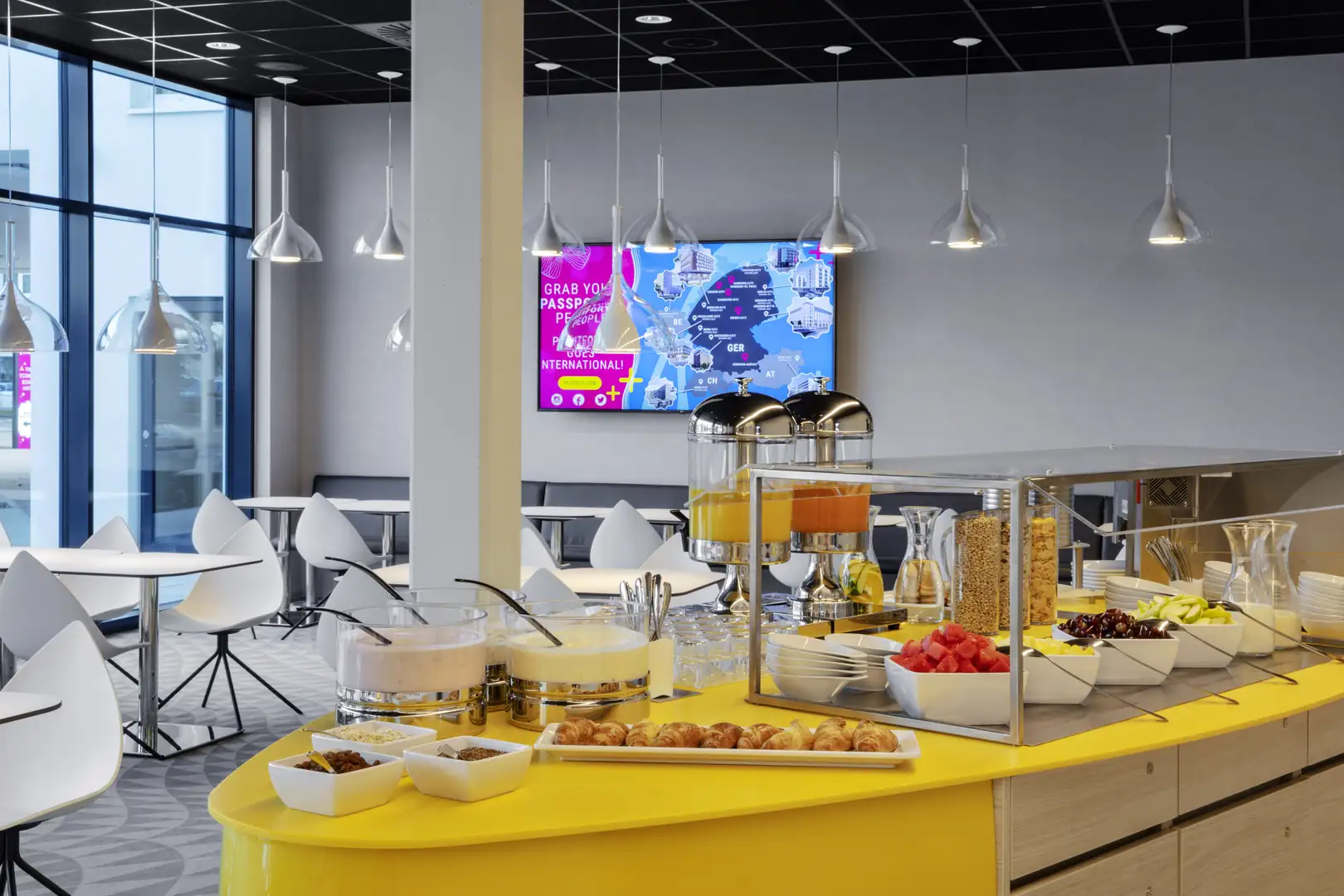 Ein modernes Frühstücksbuffet mit frischen Früchten und Getränken in einem stilvollen Raum.