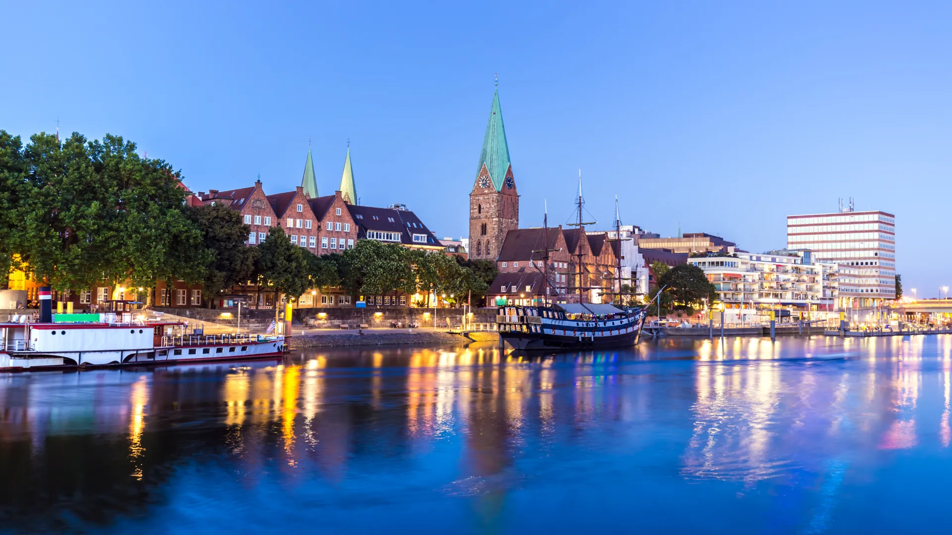 Altstadt von Bremen bei Dämmerung mit grünen Türmen.
