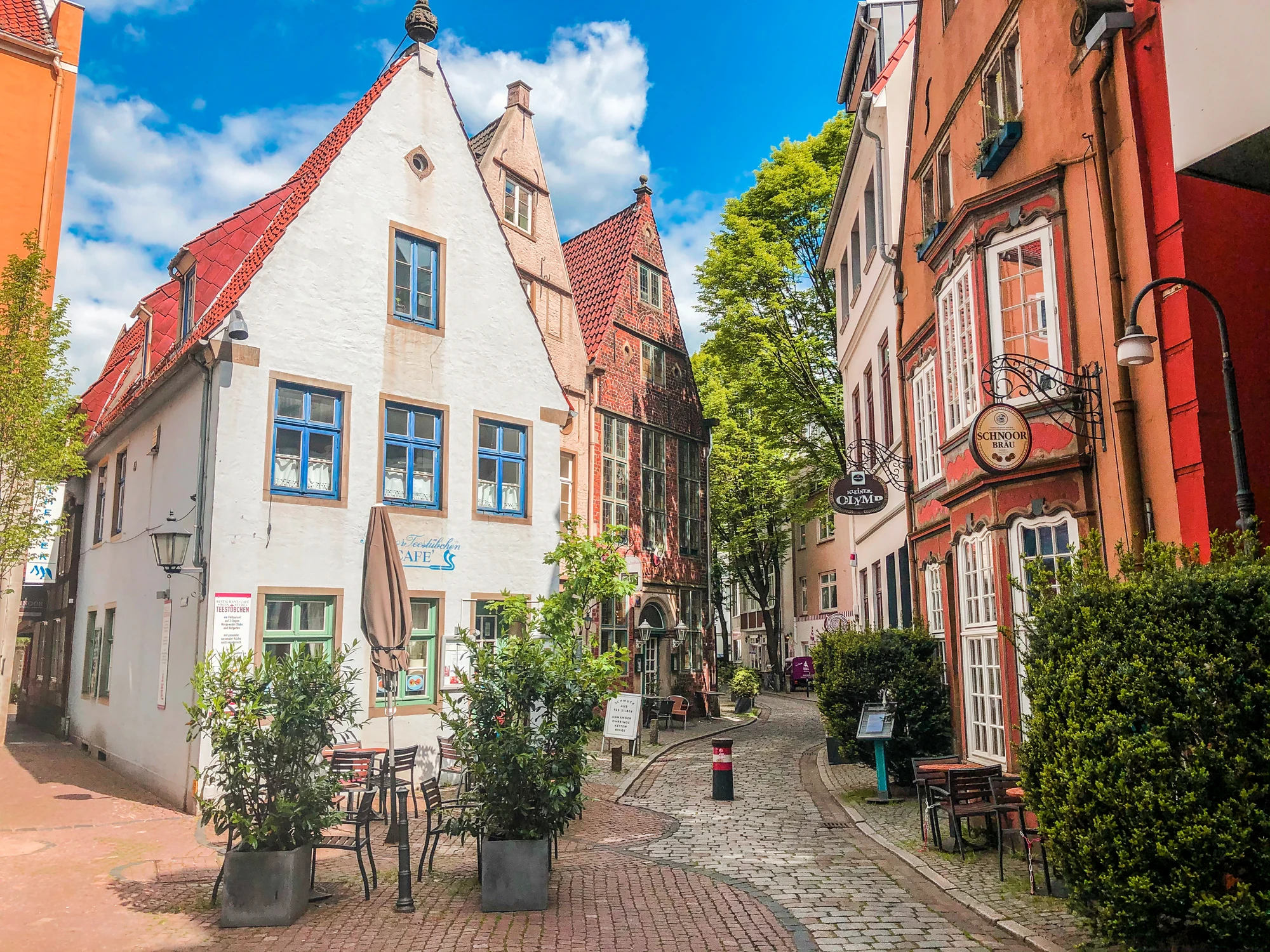 Blick in das Schnoorviertel in Bremen mit Cafés und Bars in Fachwerkhäusern und Kopfsteinpflaster bei Sonnenschein