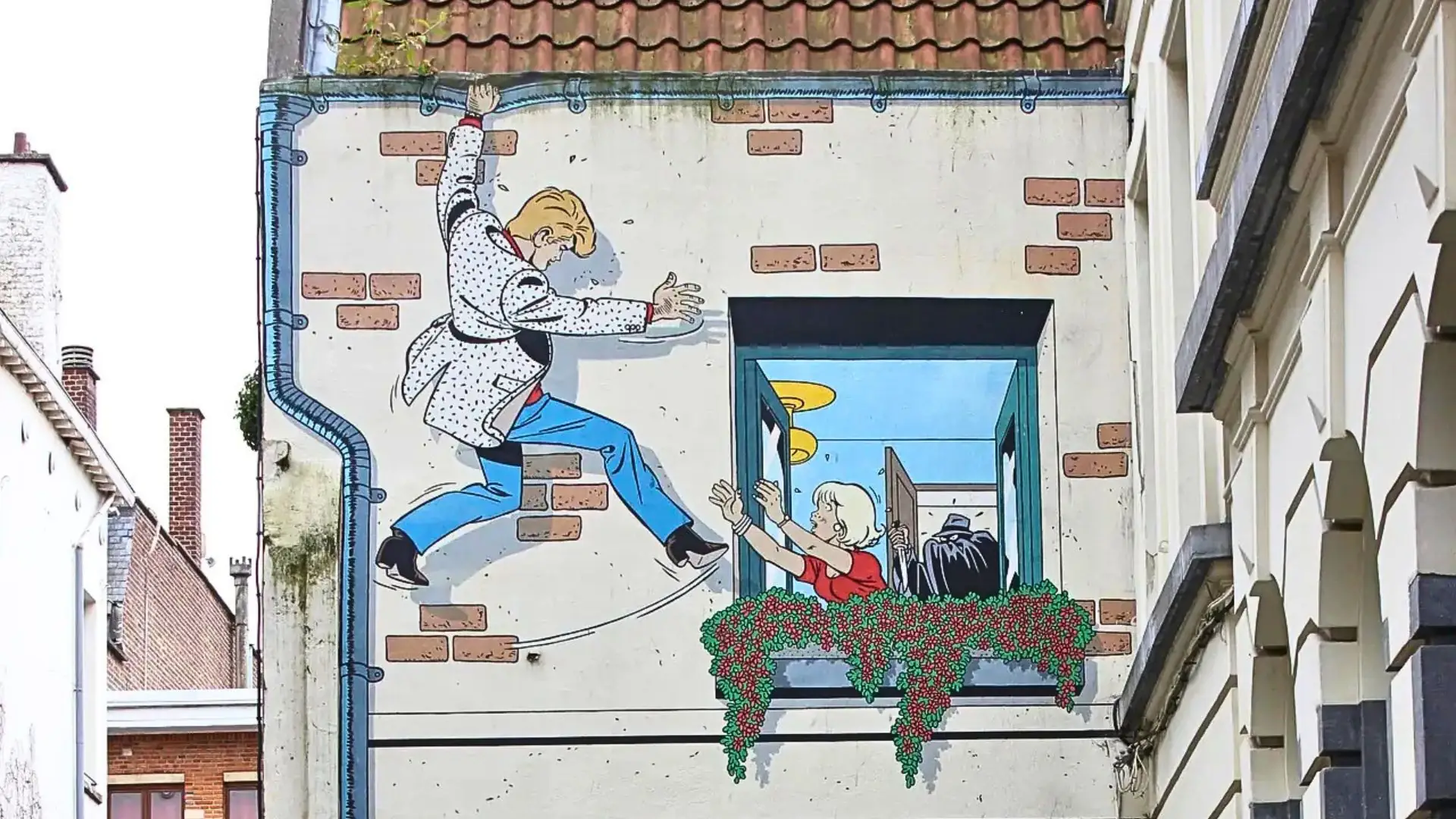 Wandgemälde an einem Gebäude zeigt einen Mann in weißem Mantel, der aus einem Fenster springt, während eine Frau mit rotem Oberteil und blonden Haaren aus dem Fenster greift, um ihn zu fangen.
