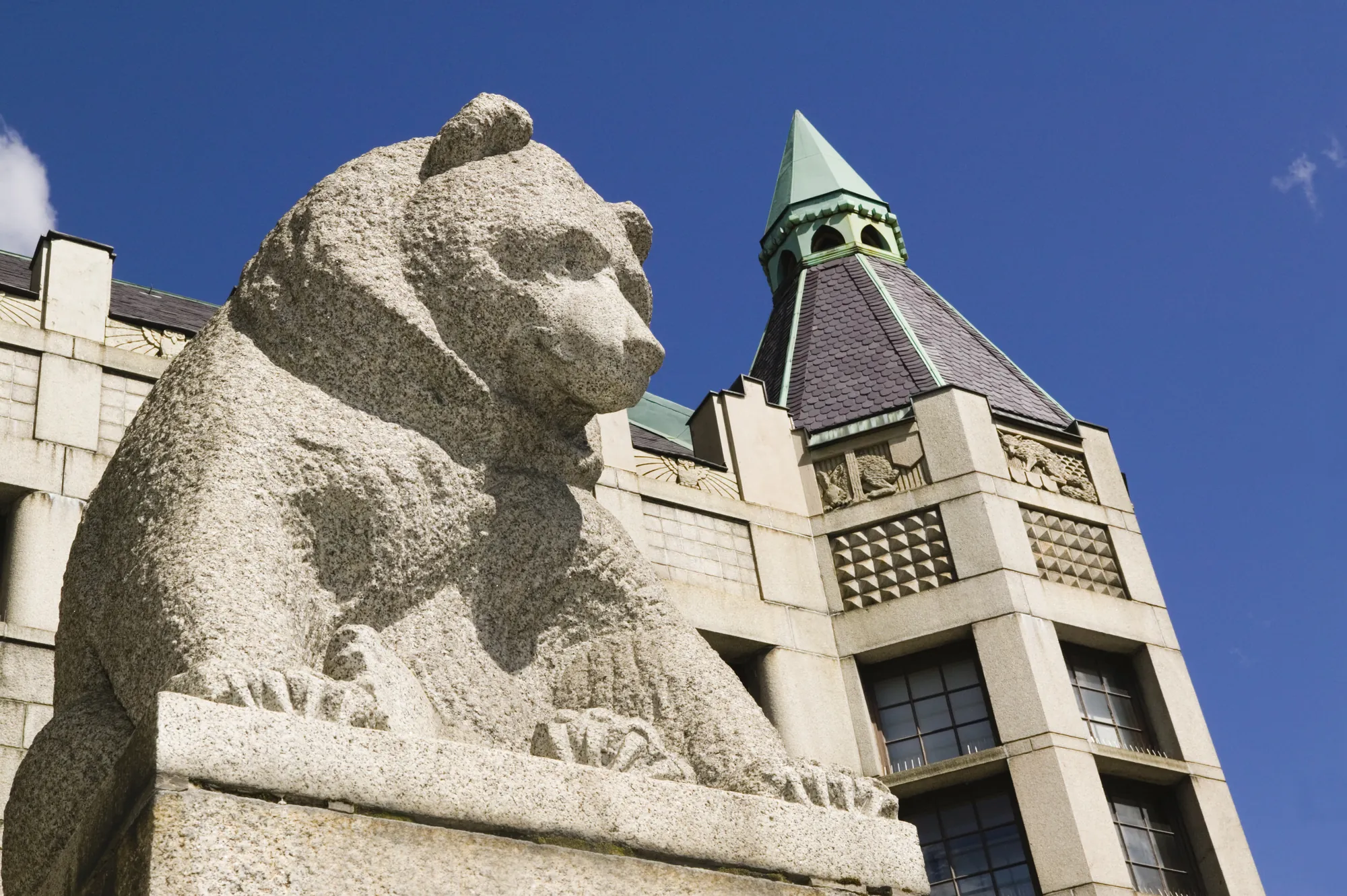 Die Bärenstatue vor dem Finnischen Nationalmuseum bei sonnigem, klarem Wetter, mit dem beeindruckenden historischen Museumsgebäude im Hintergrund.