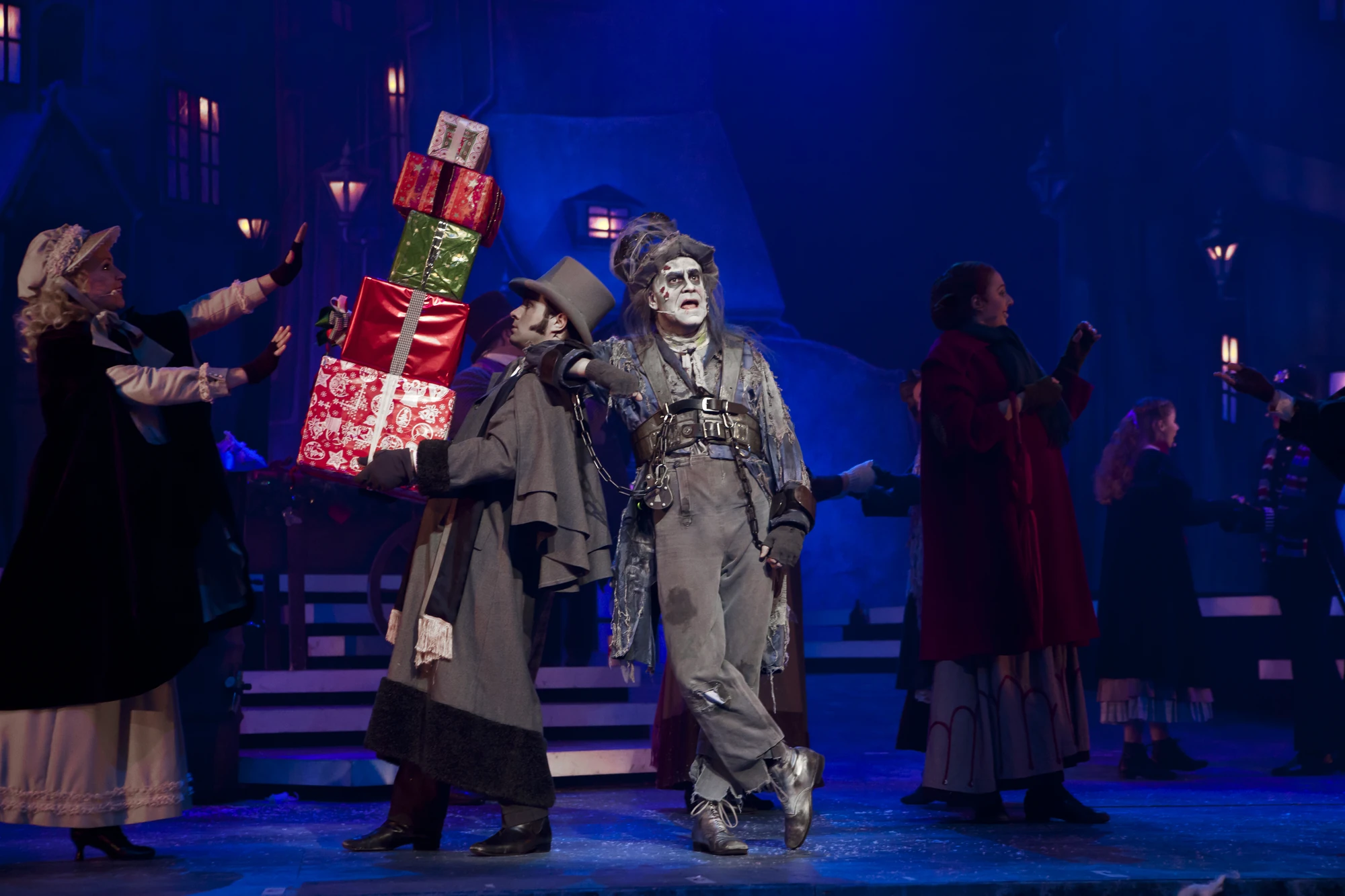 Schauspieler auf der Bühne mit Geschenken in einer weihnachtlichen Aufführung.